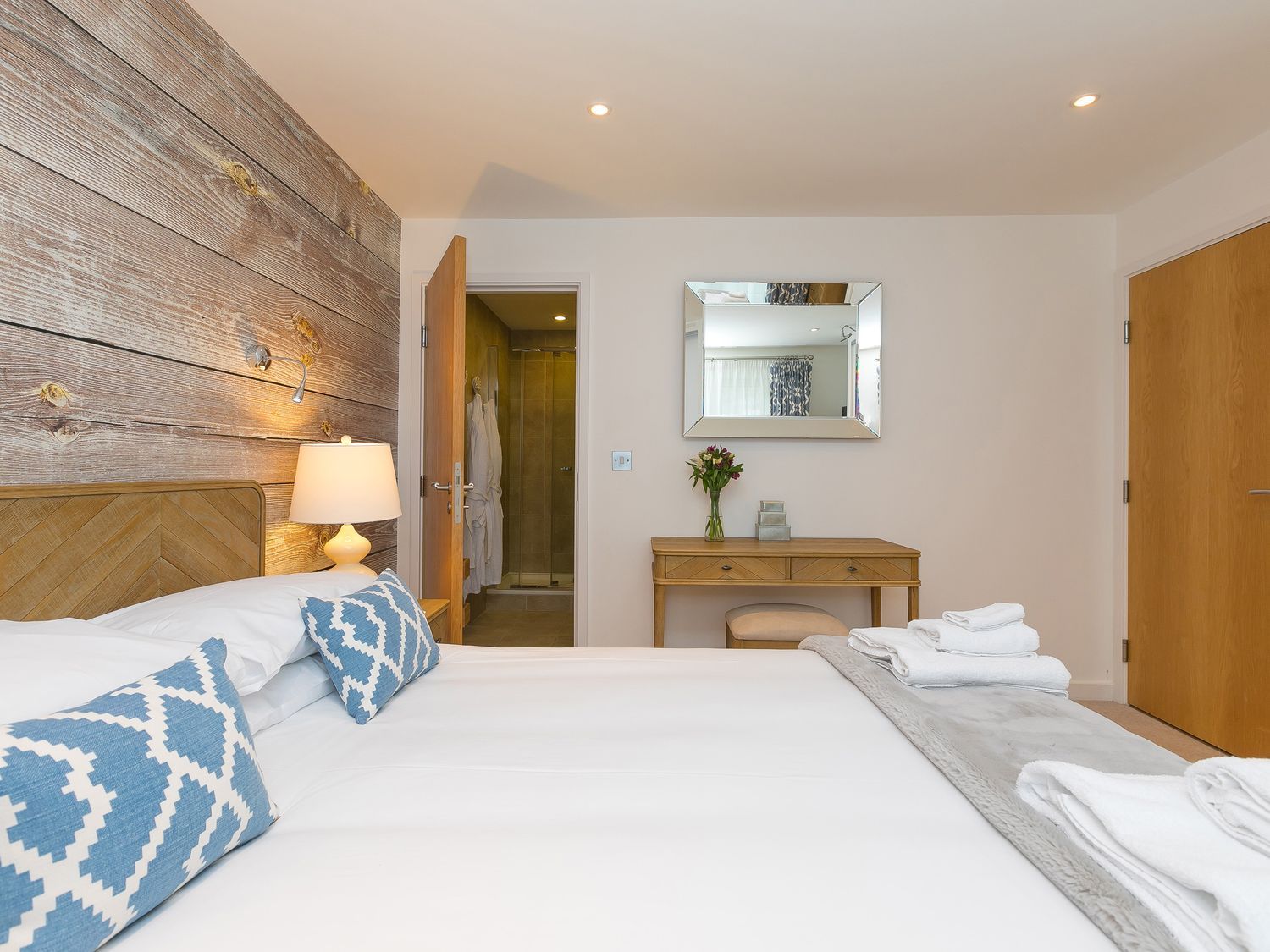 A bedroom with a bed and a mirror at Far Cliffs in St. Ives