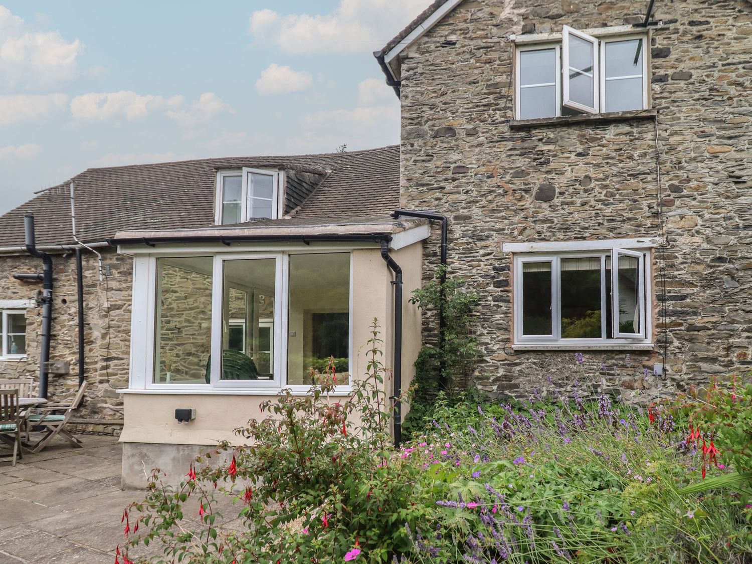 A house with windows and garden flowers at Hafod in Llangollen