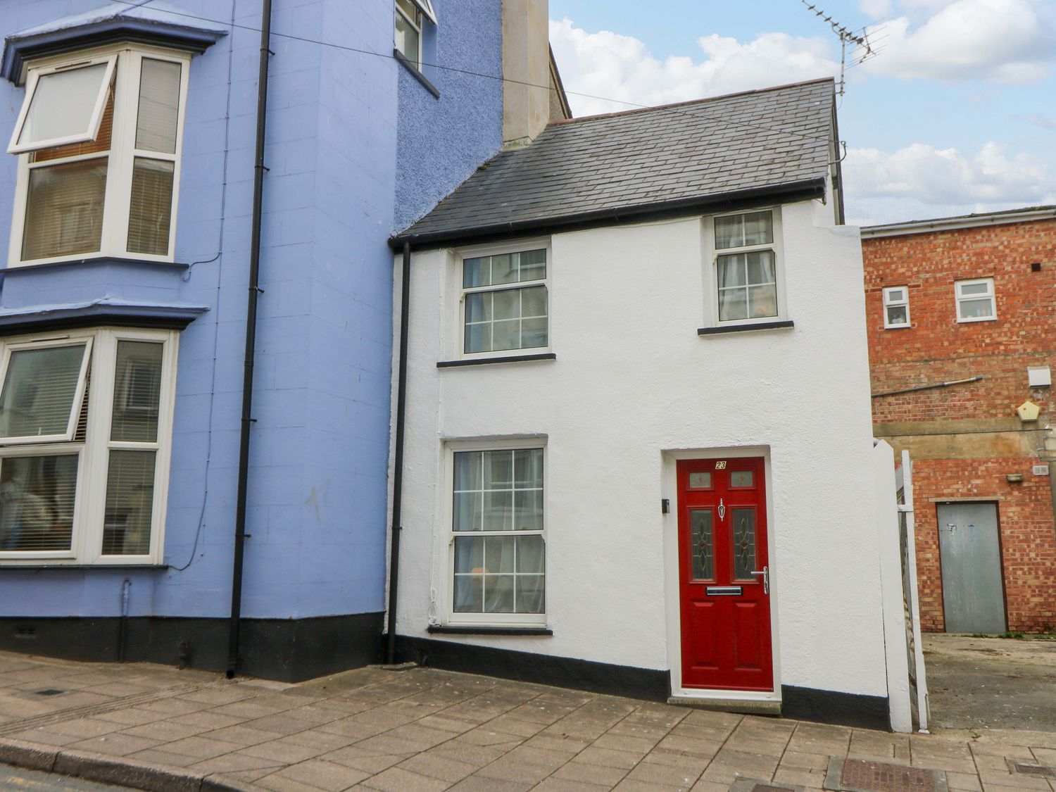 A house with a red door and windows at No.23 Queen St Aberystwyth