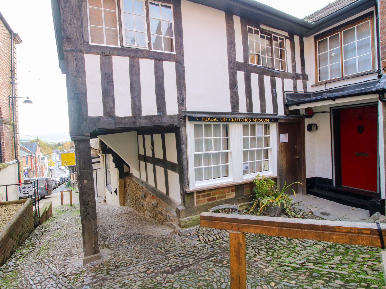 A house with a museum sign and cobblestone pathway at 41 High Street in Bishop's Castle