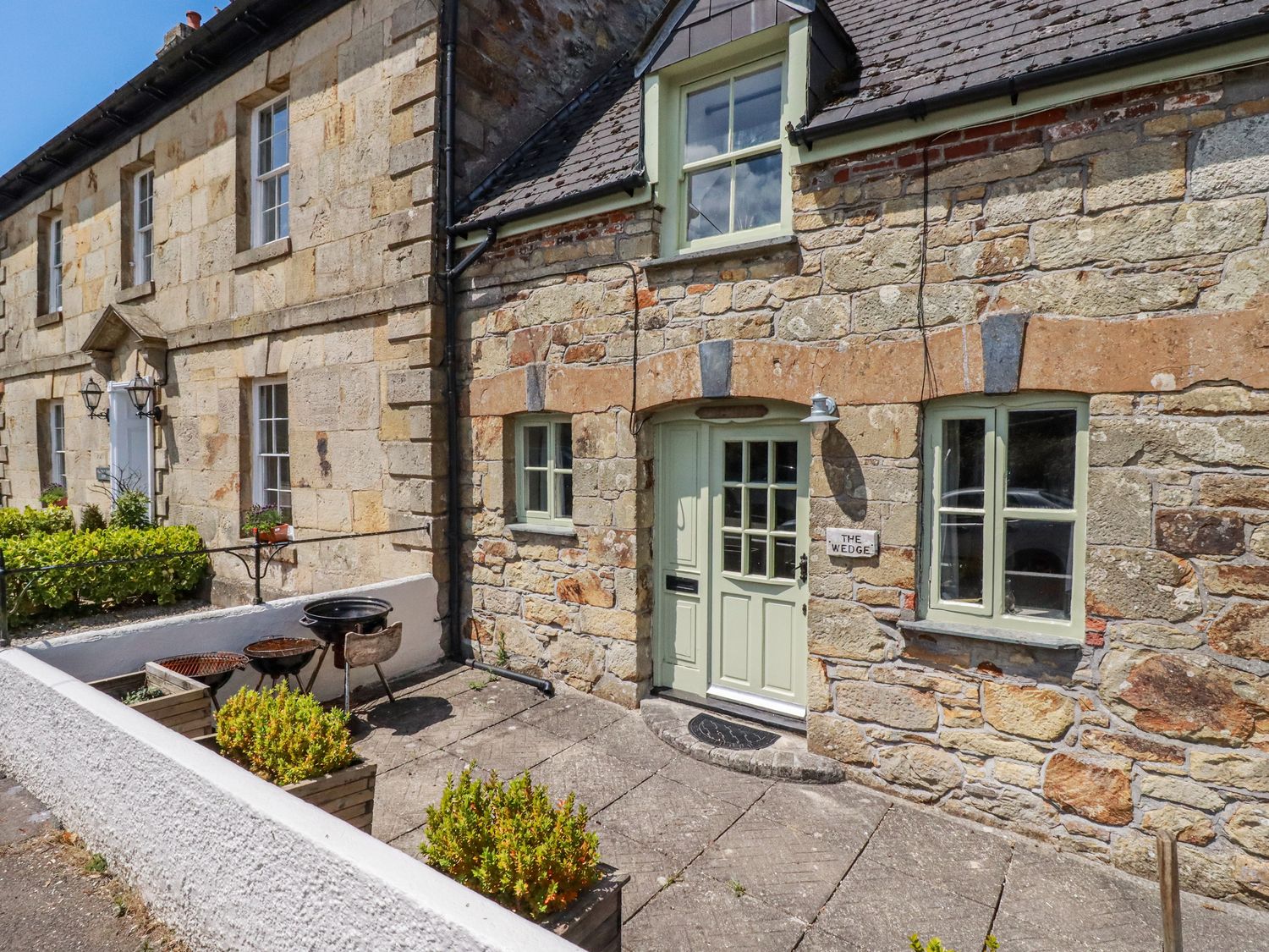 An outdoor area with a stone building and planters at The Wedge in Mitchell near Summercourt