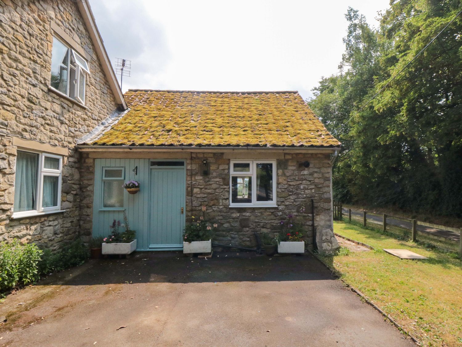 A stone cottage with a blue door and parking area at The Annex in York