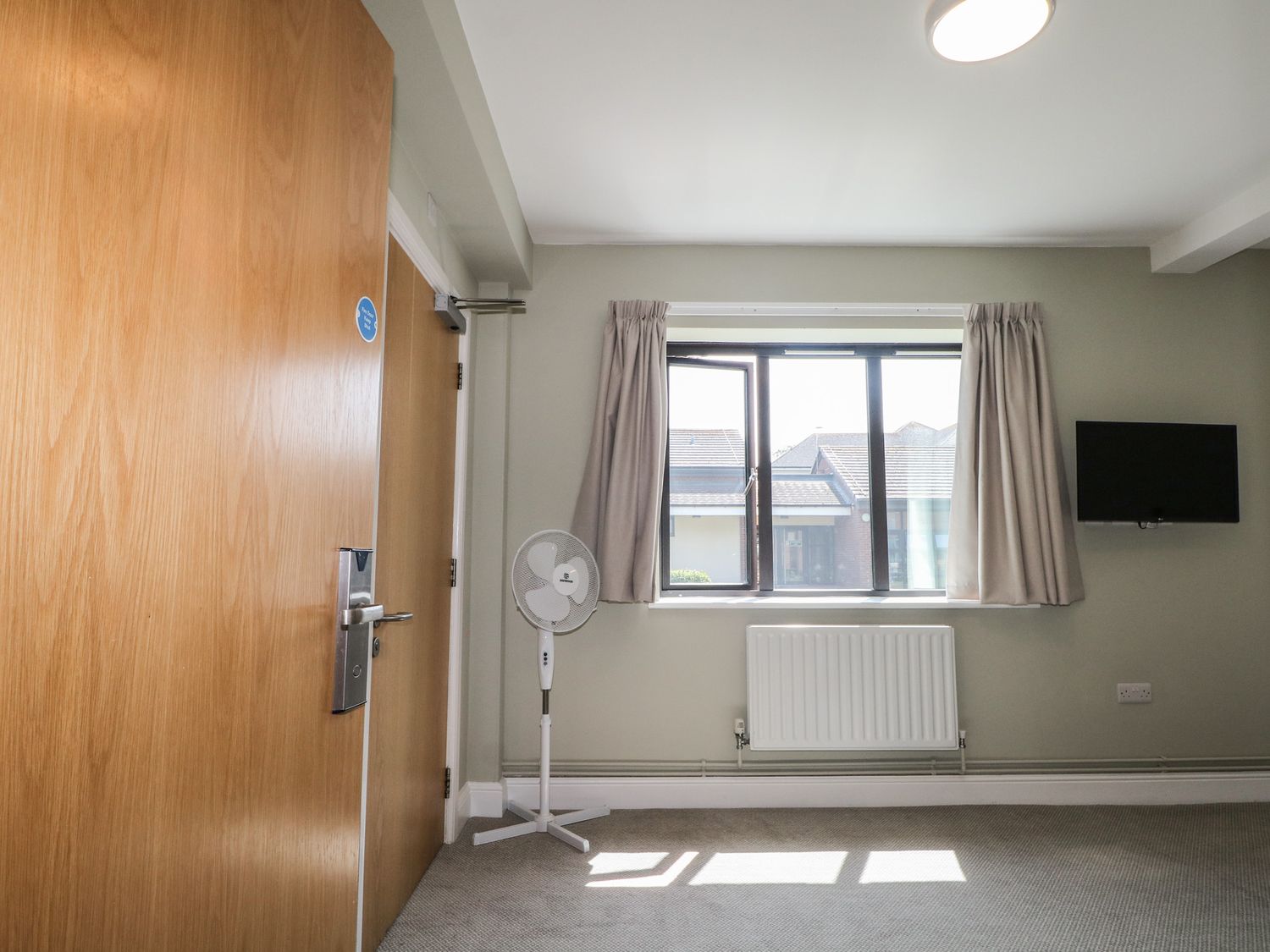 A bedroom with a window and fan at Bedroom 6 in Littlehampton