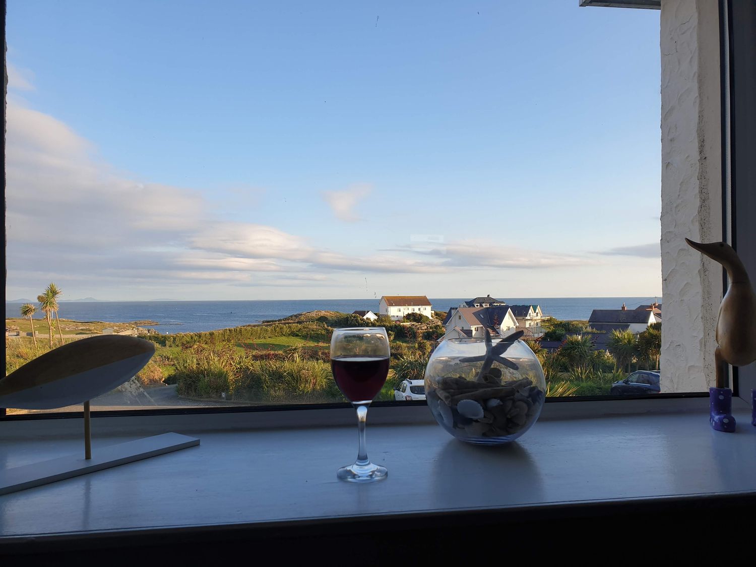 A window view with a glass of wine and decorative items at Lady of the Lake Suite