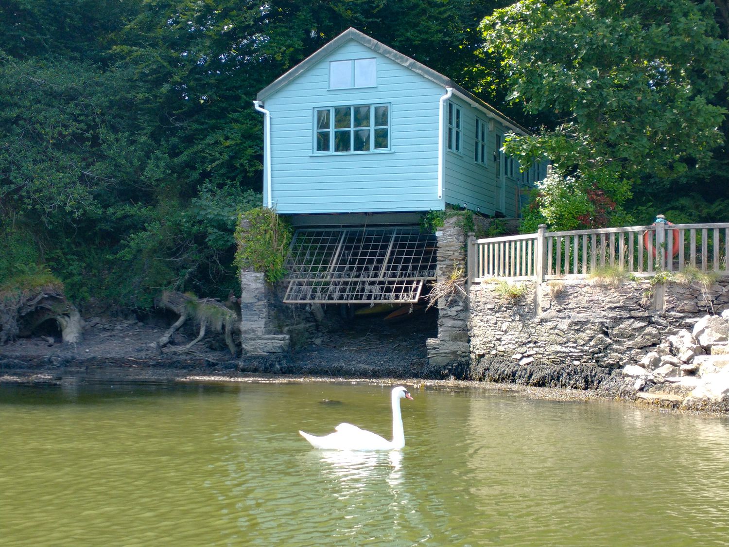 A house on stilts beside water at The Sharpham Boat House in Ashprington