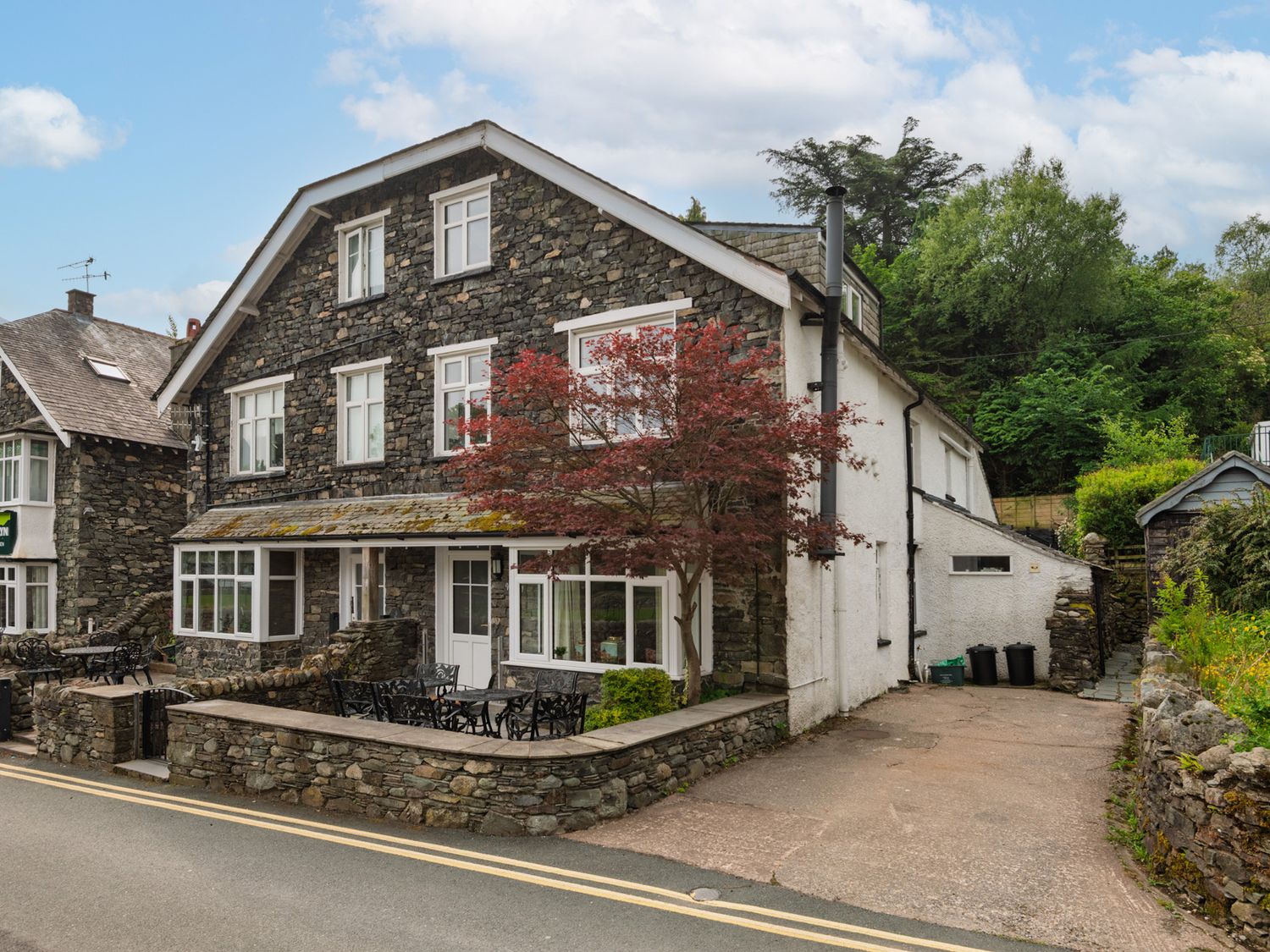 A house with stone walls and trees at Moss Crag in Glenridding
