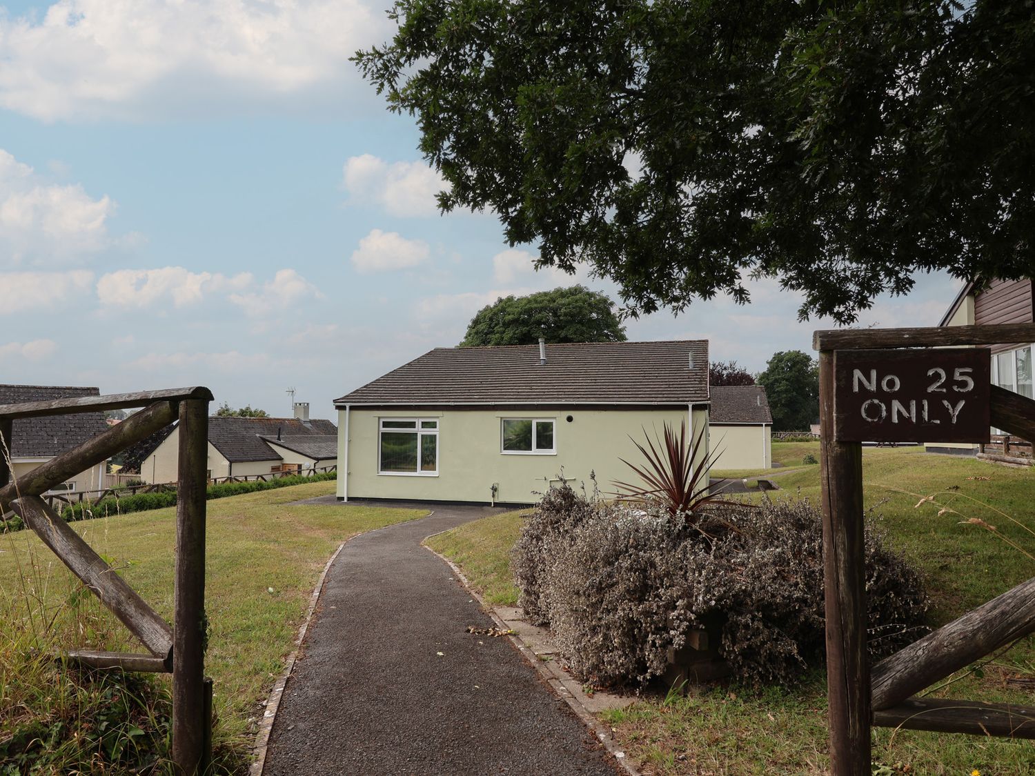 A bungalow with pathway and sign at Harcombe House Bungalow 25 Chudleigh
