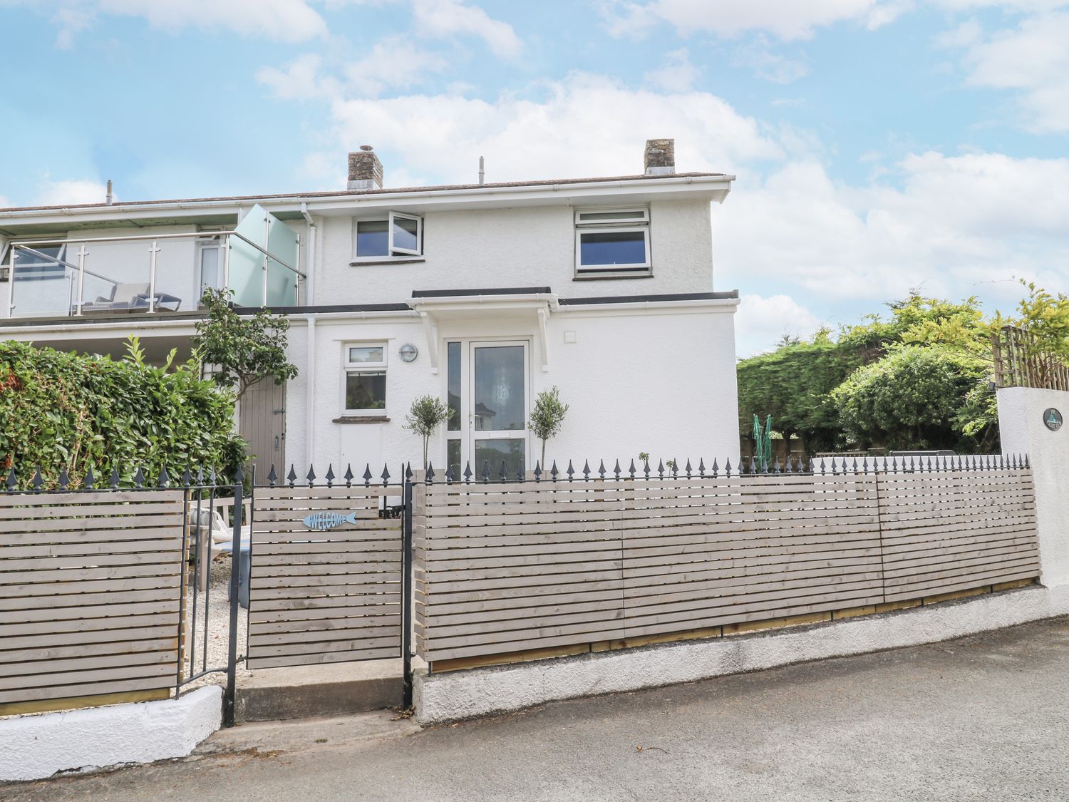 A house with a fence and door at 1 Island View in Thurlestone