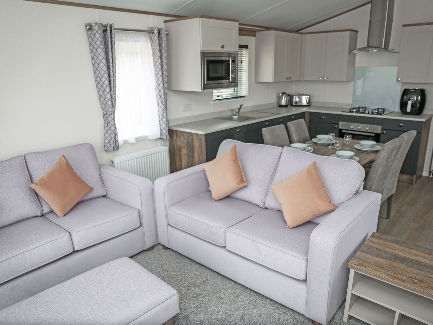 A living room and kitchen with furniture and appliances at Harbour Haven - Hayling Island
