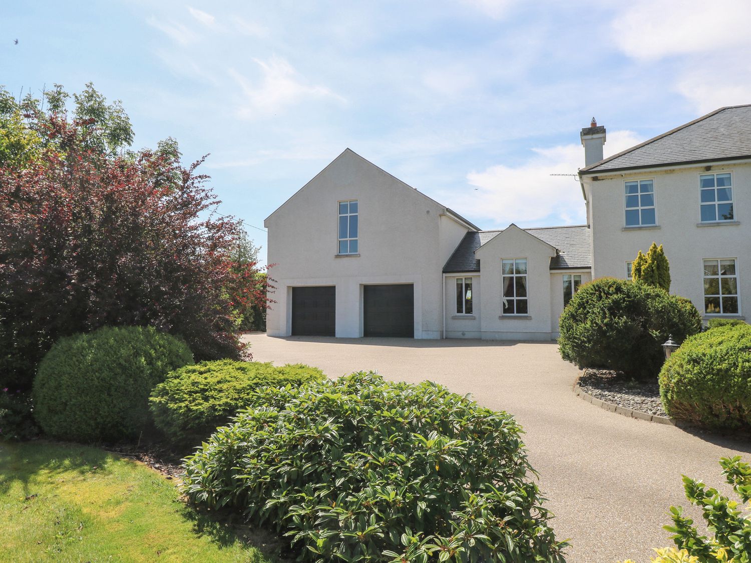 A house with a garage and garden at The East Wing Apartment in Claremorris