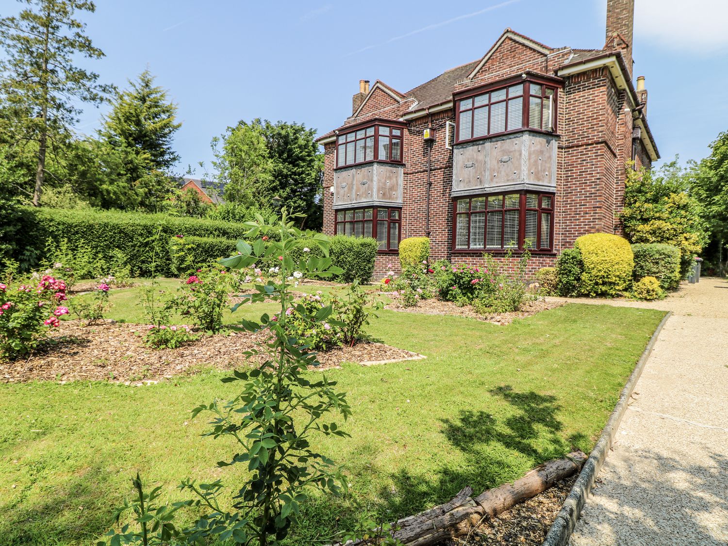 A garden with flowers and a building at Bentfield House Rotherham near Whiston