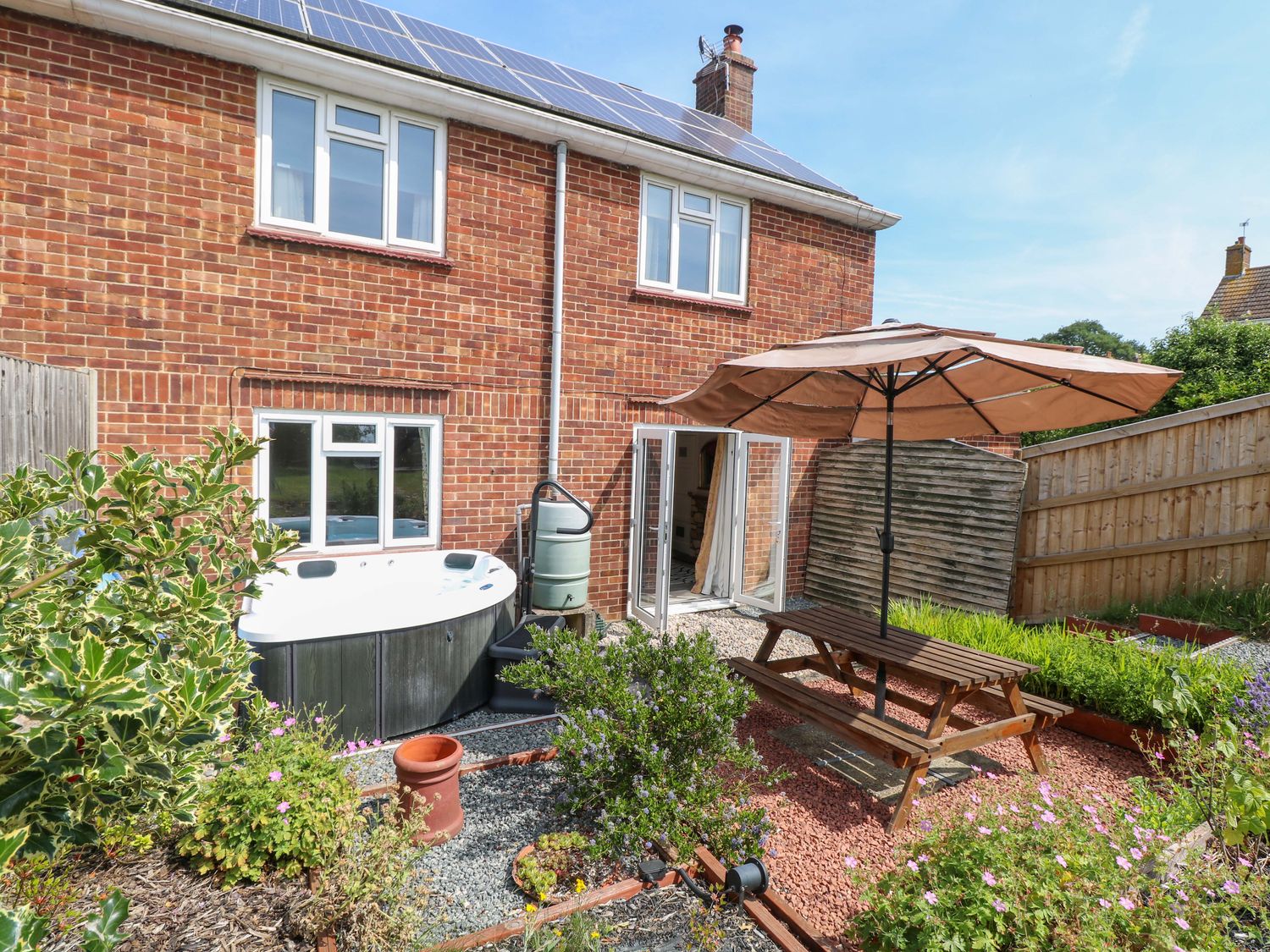 A garden with a hot tub and table at 3 Birkbeck Way in Norwich
