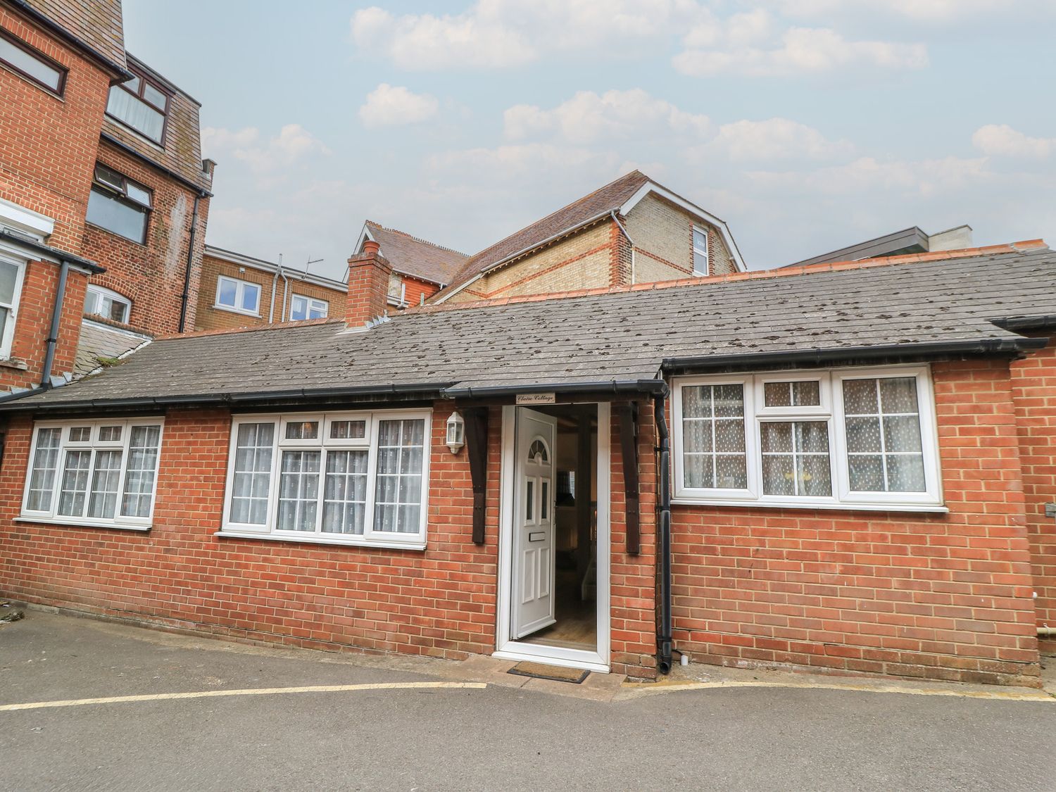 A brick building with a front door and windows at Claire Cottage in Swanage
