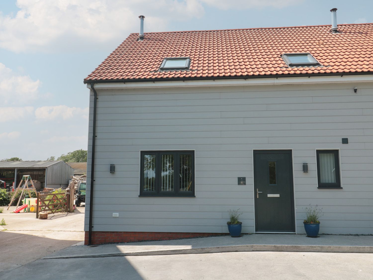 Front view of a house with a door and windows at 1 The Stables Highbridge