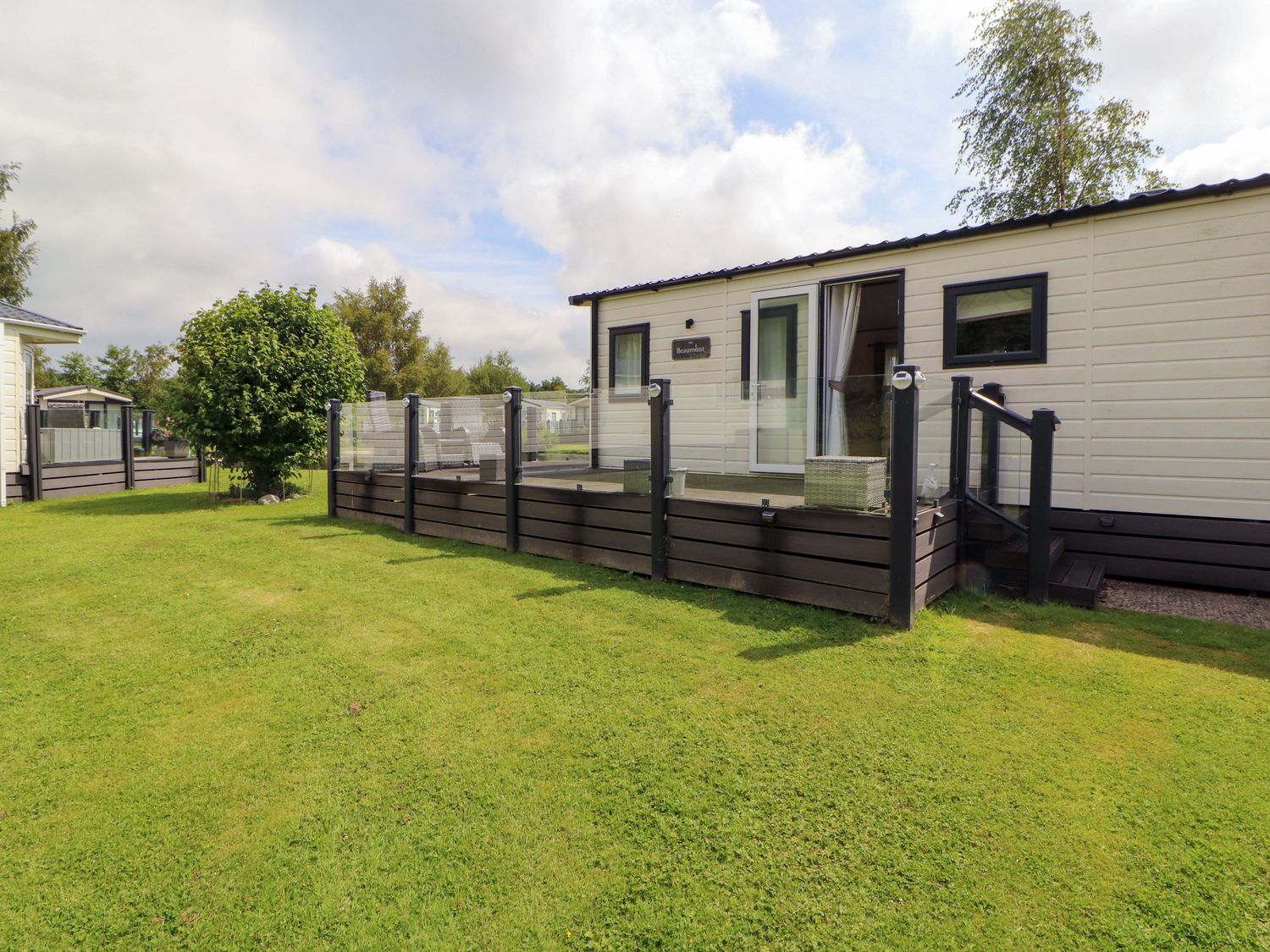 An outdoor area with a holiday home and landscaping at 22 Yealand in Carnforth