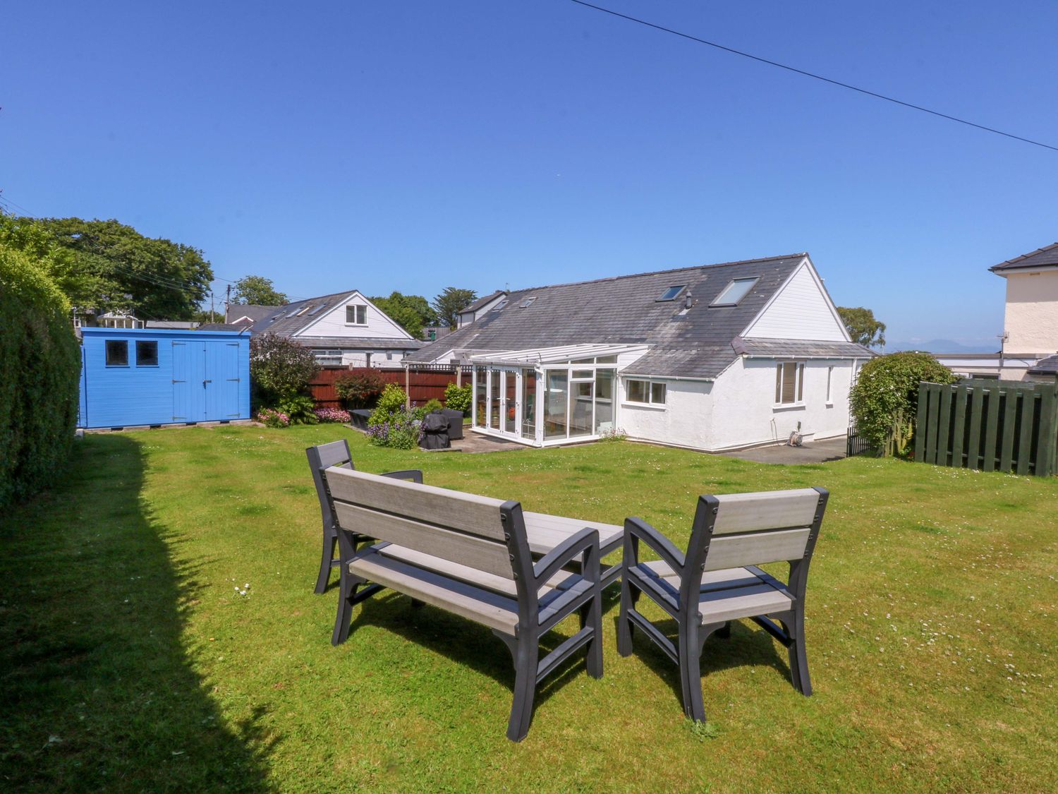 A garden with a patio set and a shed at Swn Y Don