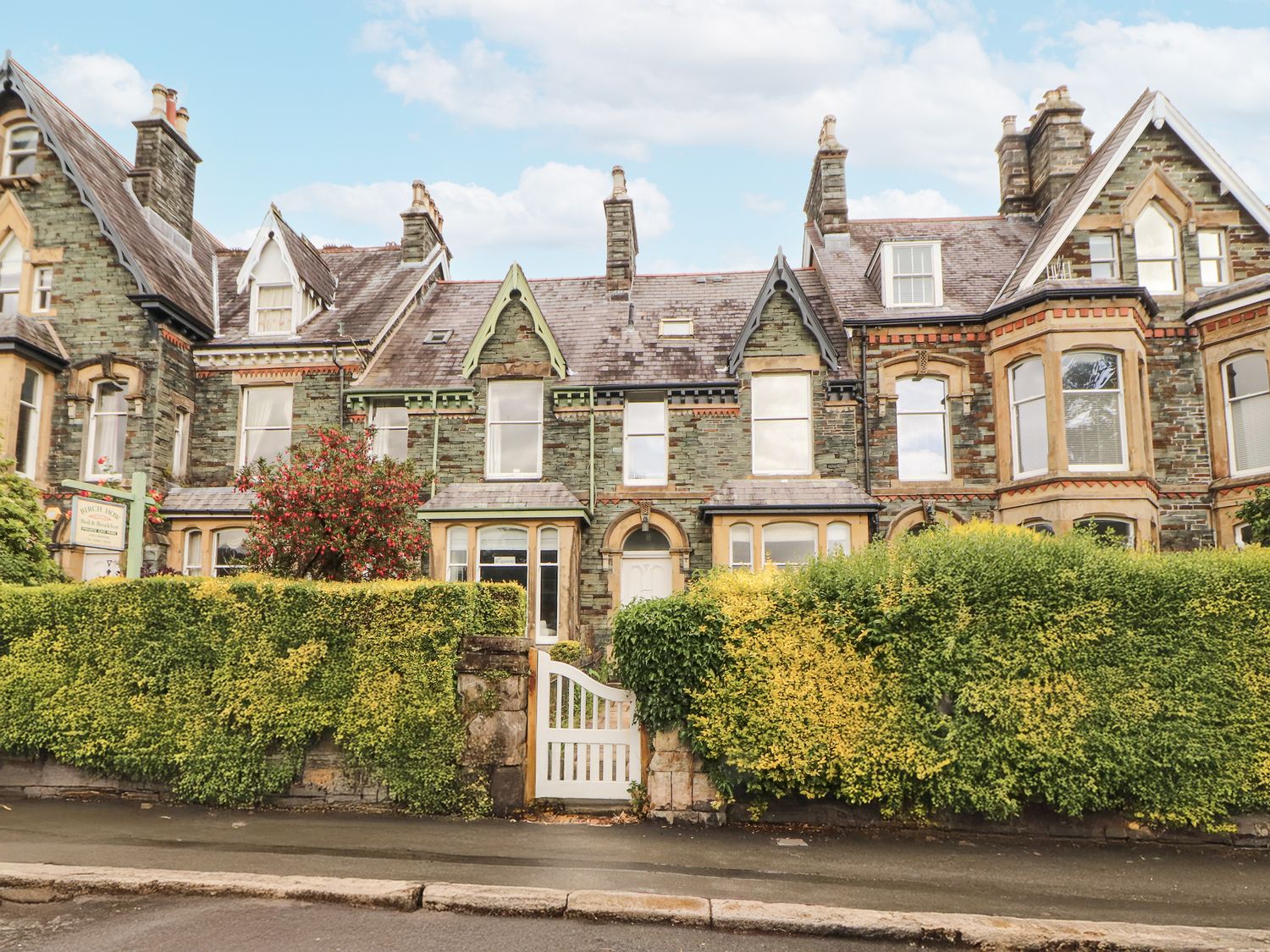 A building with windows and doors surrounded by a hedge at 43 Station Road in Keswick