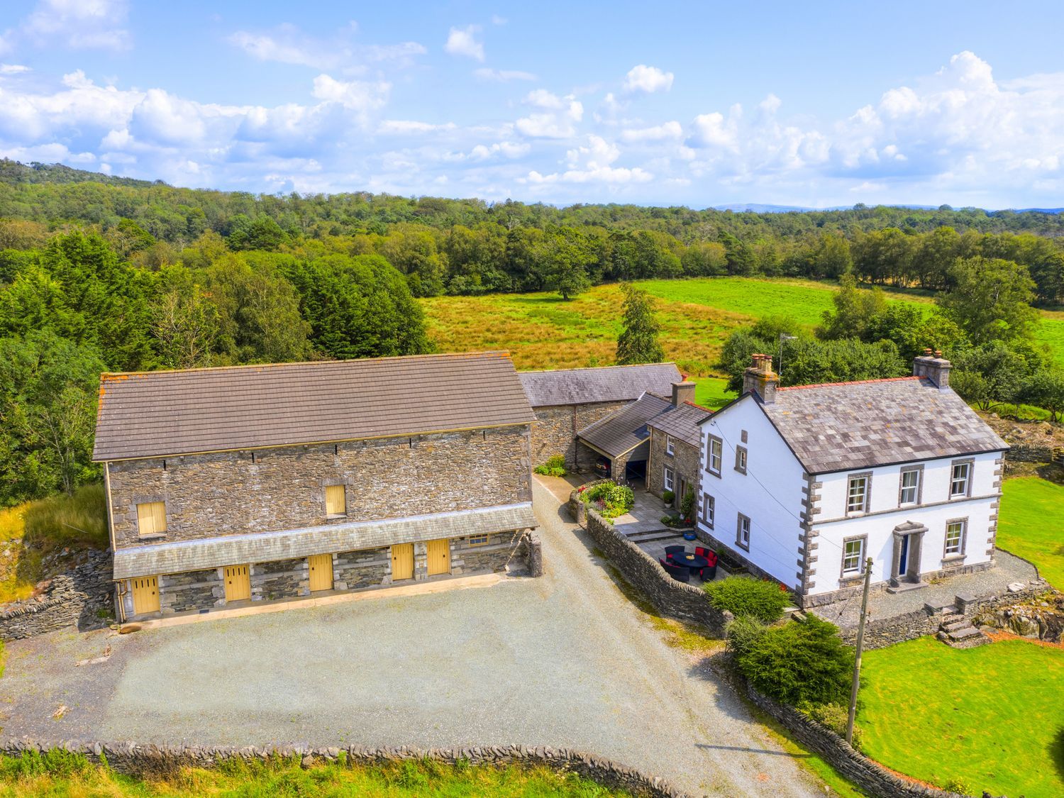 A house and barn with gravel driveway and fields at Grove House in Grange-Over-Sands