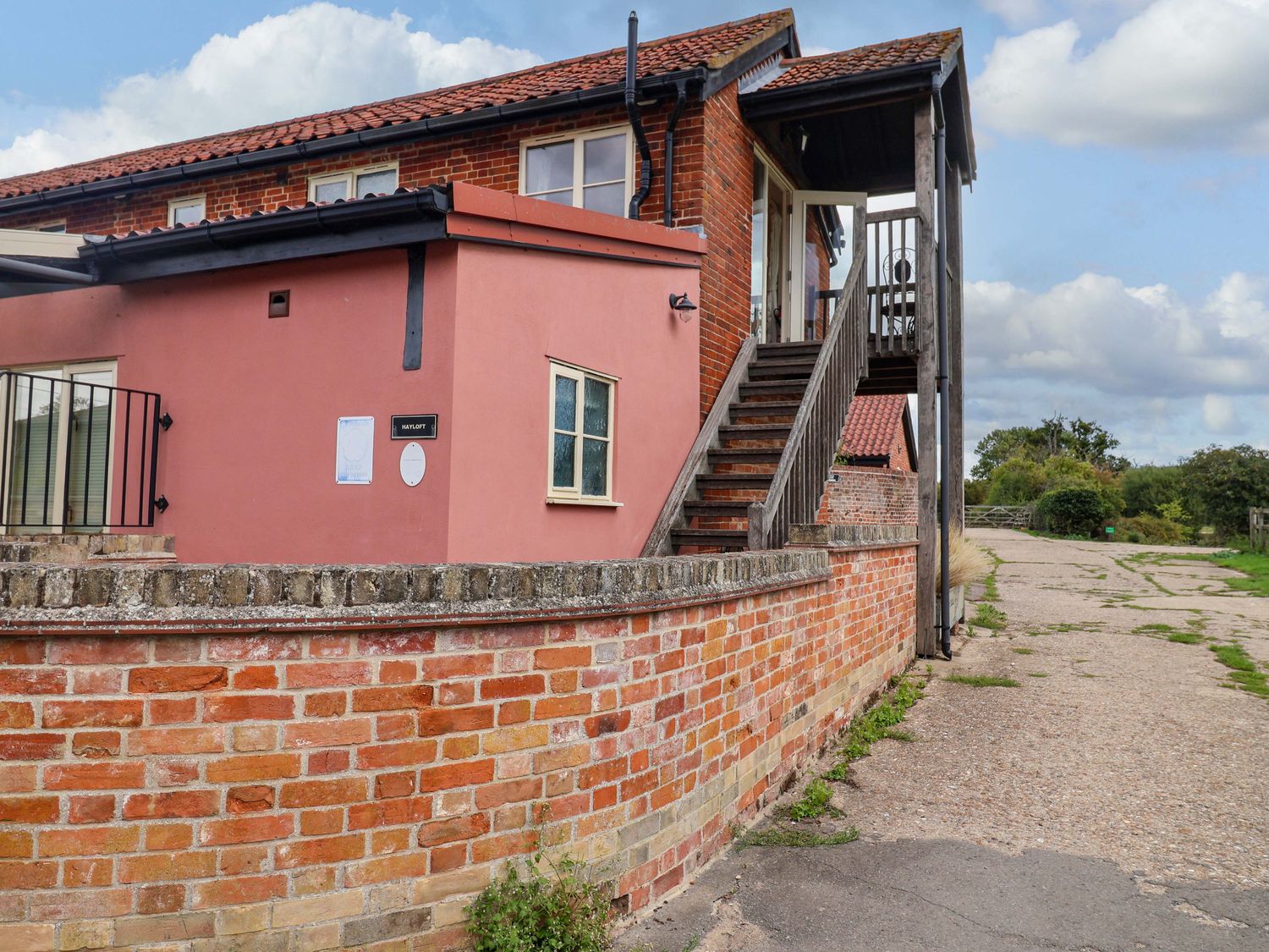 A brick building with stairs and signage at Hayloft in Ipswich