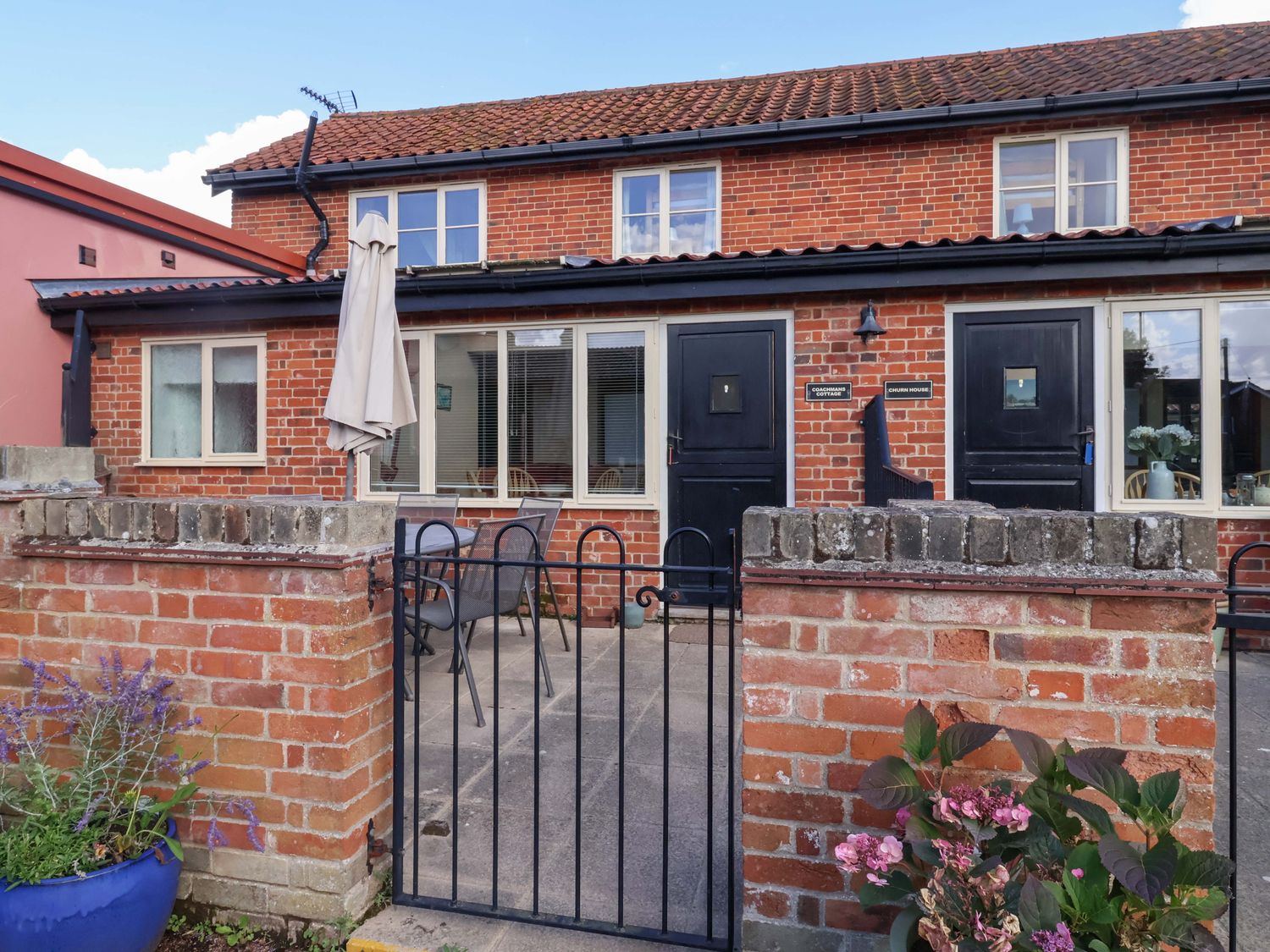 An outdoor area with a brick building and gate at Coachman's Cottage in Ipswich