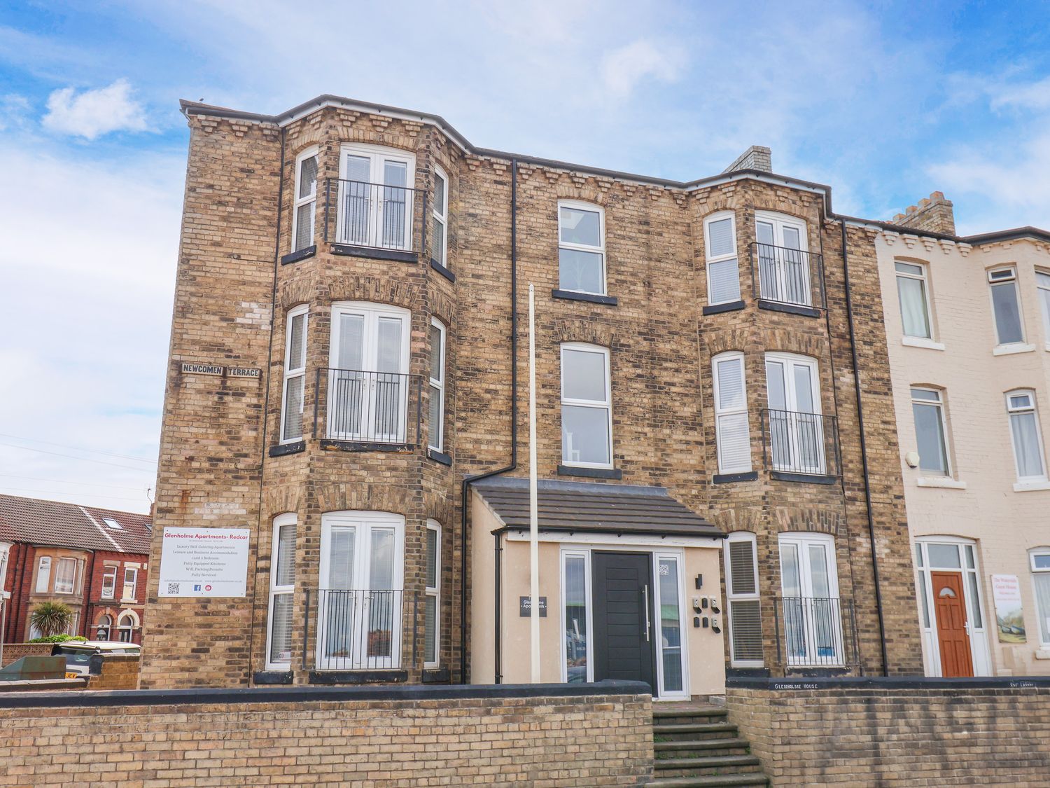An apartment building with balconies and a sign at Apartment 4 (1 bed) Redcar