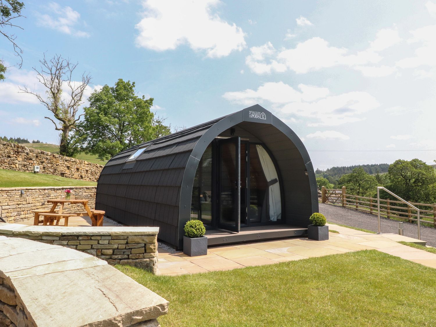 A glamping pod with a table and planter at Barley near Nelson