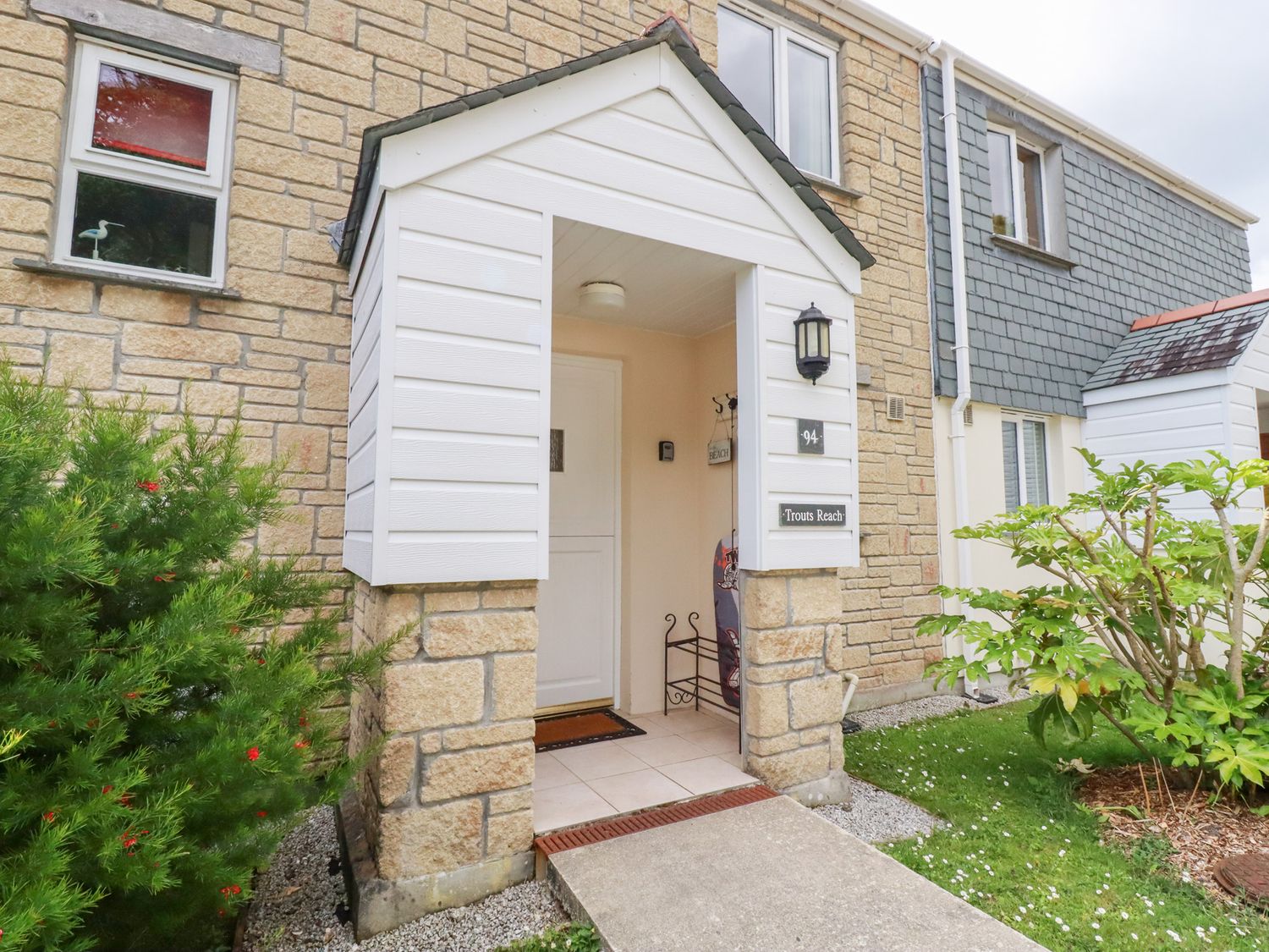 An entrance with a door and plant at Trouts Reach in Falmouth