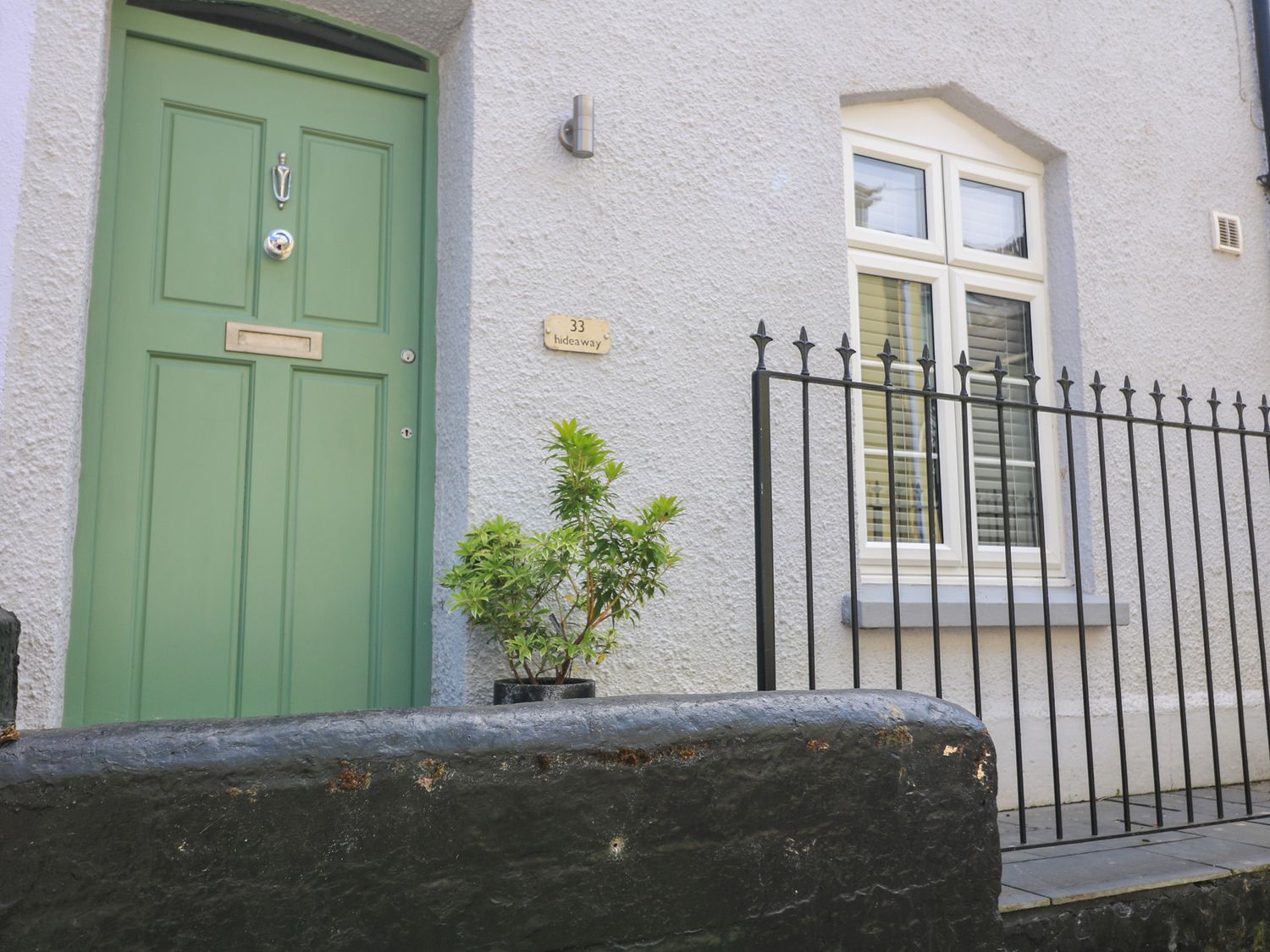 An entrance with a green door and a window at The Hideaway