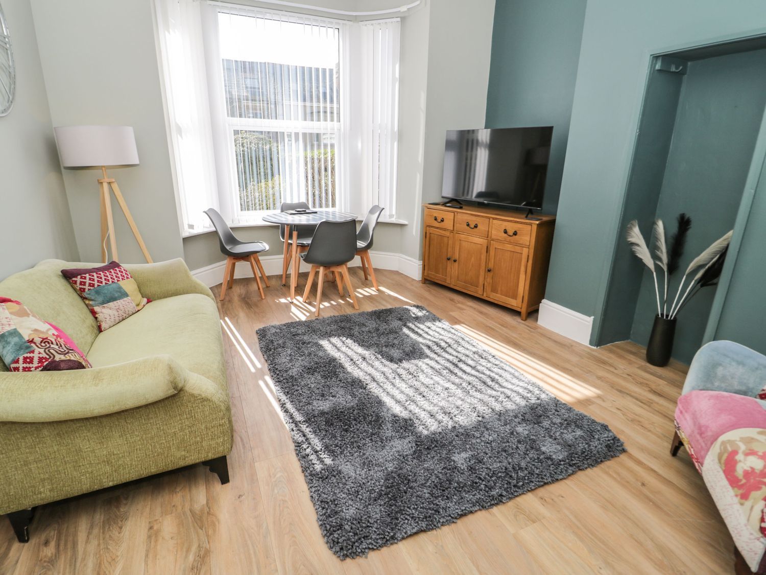 A living room with a sofa, table, and television at Flat 1A, Mona House, Conwy