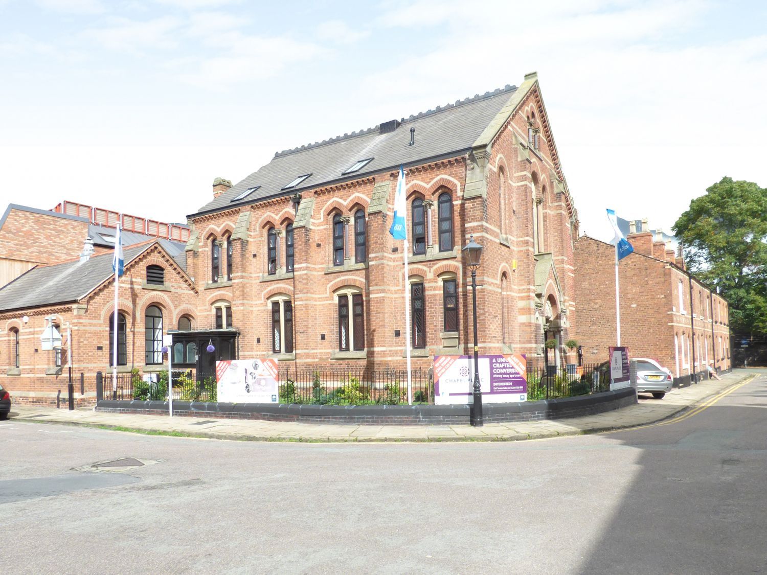 A brick building with flags and signage at 1 Chapel Place Chester