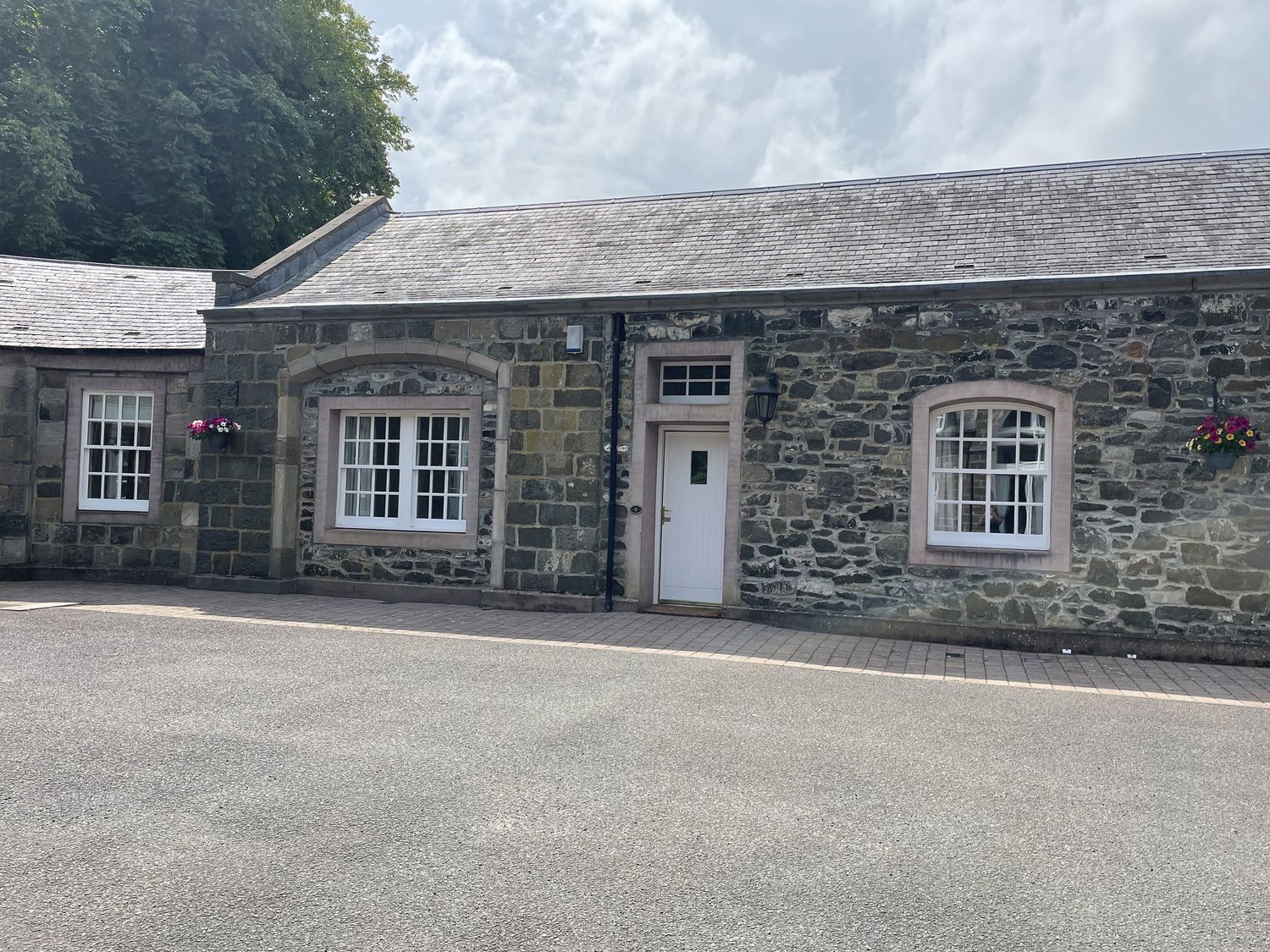 An exterior view of a stone building with windows and door at Coach House 4 Perth