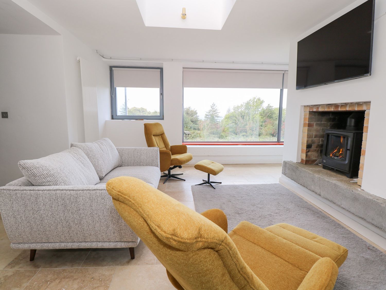 A living room with a sofa, chair and television at Sruthan Lodge in Ballinaglera near Drumshanbo, County Leitrim