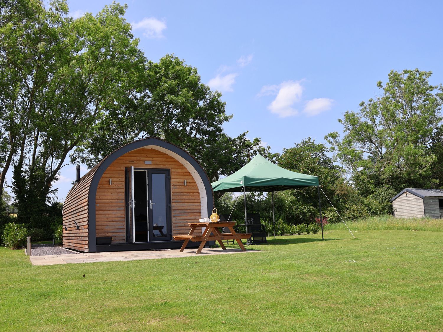 A cabin with a table and tent in an outdoor space at Honeypot Hideaways - Clover