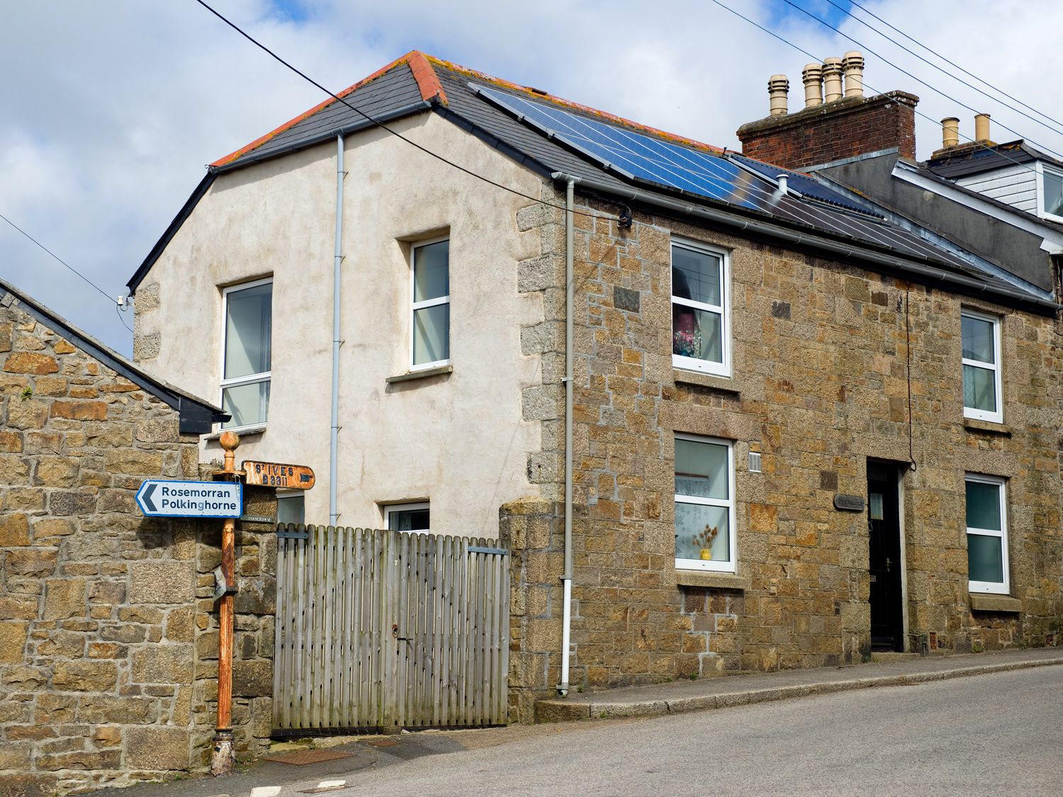 A house with a signpost and gate at Chyancrowse Gulval