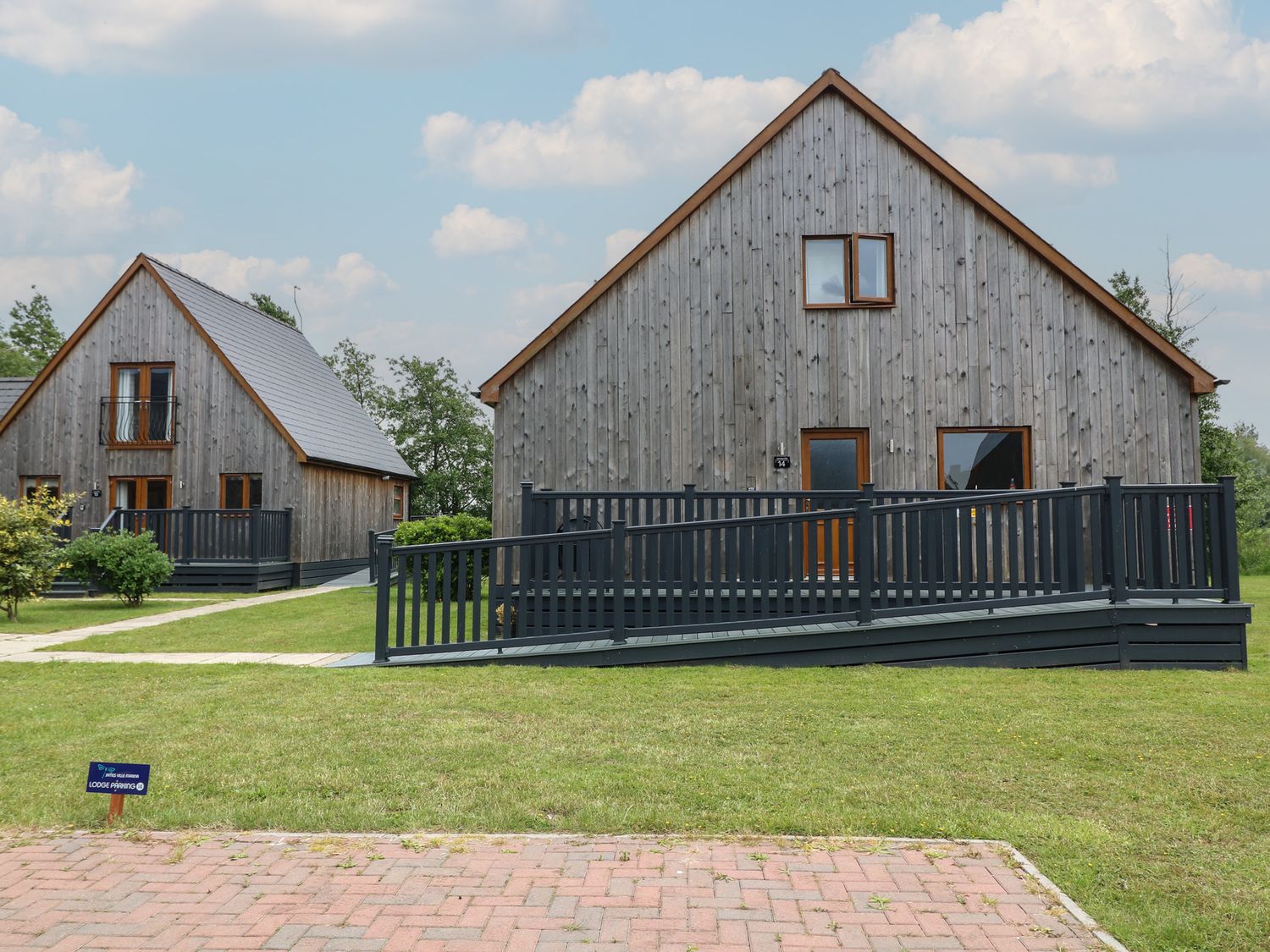 Two wooden houses with ramps and grass area at Lodge 14 in Brigg