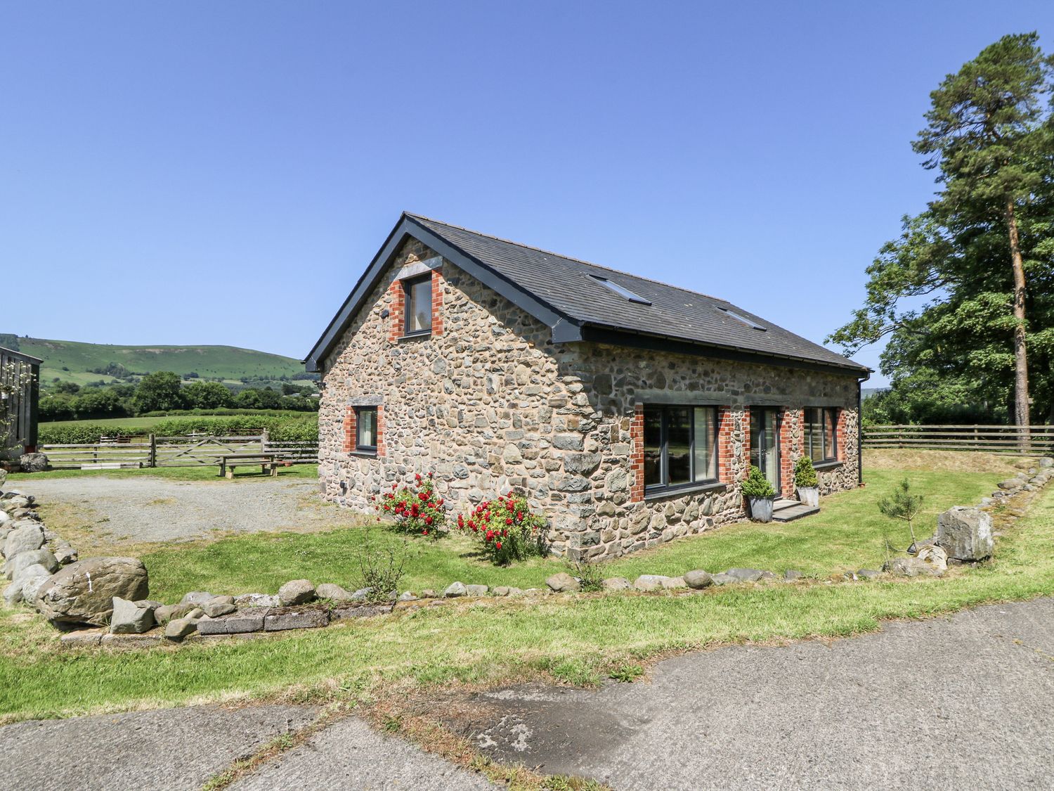 A stone house with garden and pathway at Little Penrhosgoch Barn in Llandrindod Wells