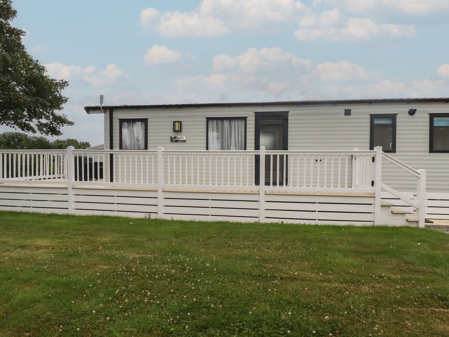 A mobile home with a deck and railing at The Maples, no. 56 Hewas Water near Polgooth