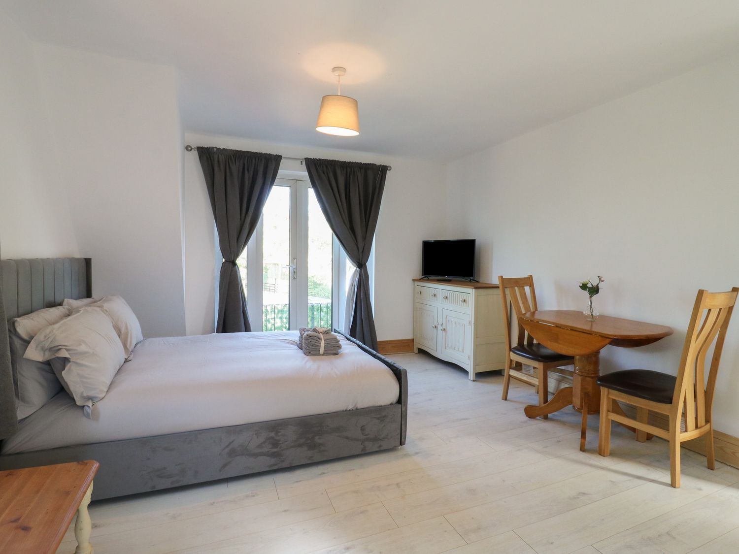 A bedroom with a bed and dining area at Sunflower Northampton