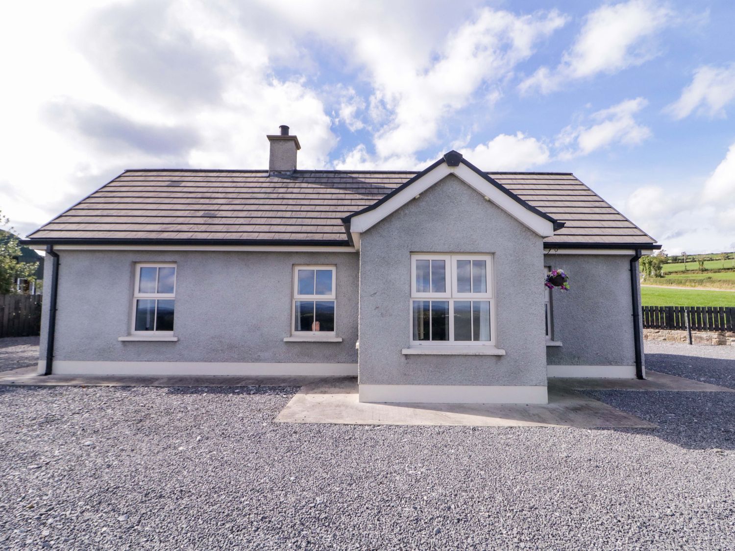 A house with windows and gravel area at Molly's Cottage in Enniskillen