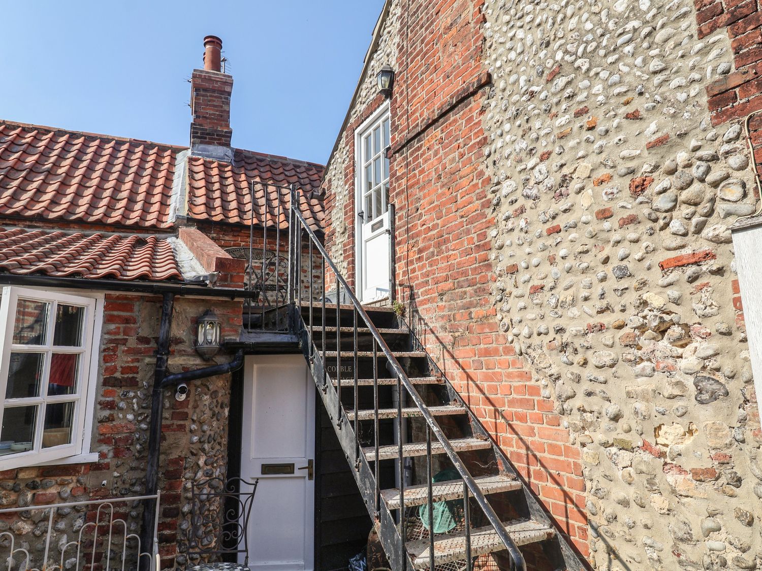 An outdoor staircase leading to a door at The Plover in Blakeney, Norfolk