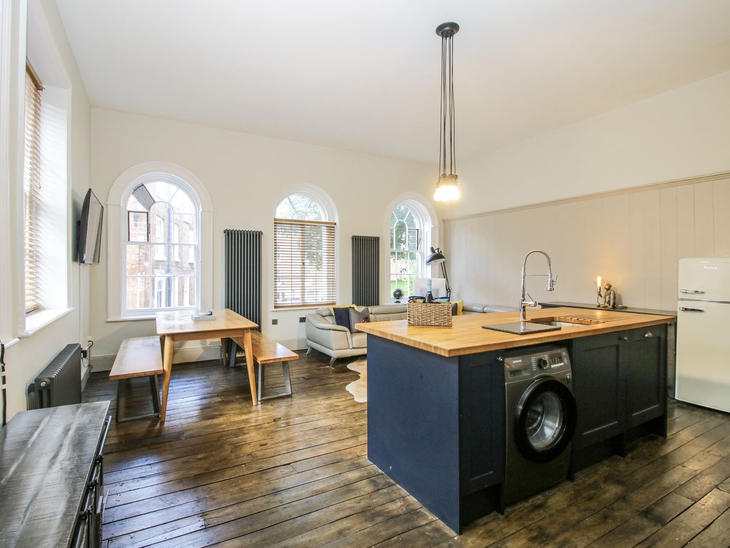 A kitchen with a washing machine and dining table at 1C College Hill in Shrewsbury