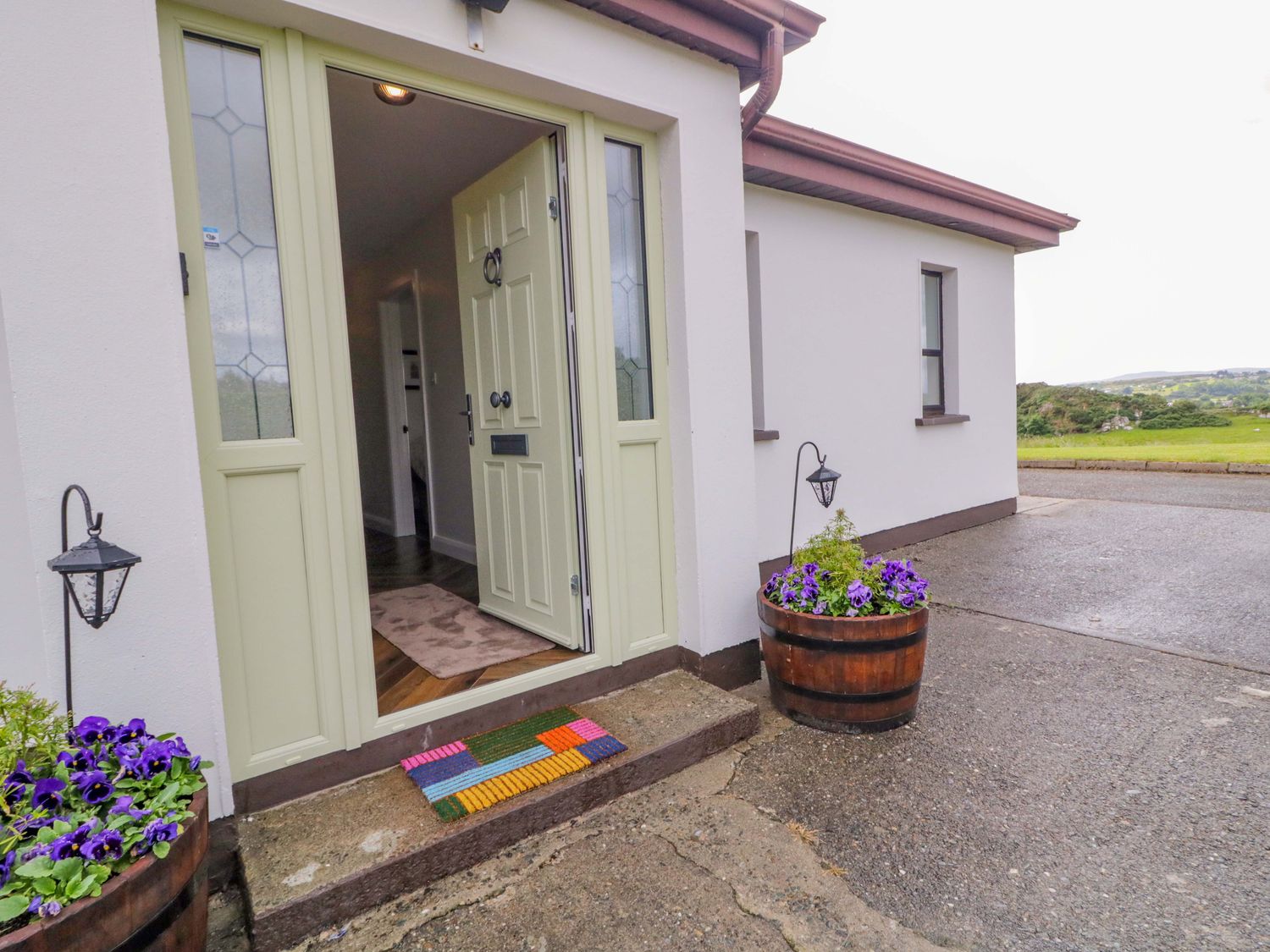 An entrance area with a front door and flower pots at Ard Na Mara