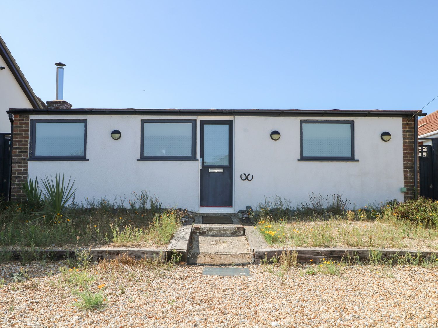 A house with a front door and windows at Harbour Road Quirky Beach Railway Carriages Pagham