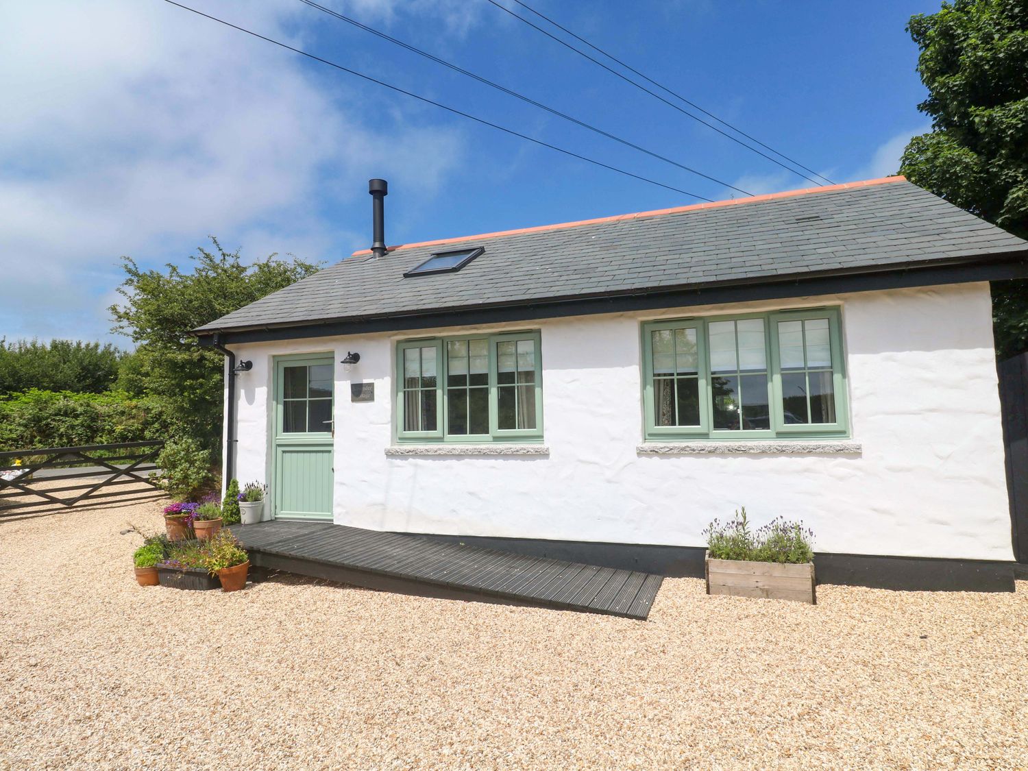 An exterior view of a cottage with a garden at Lavender Cottage