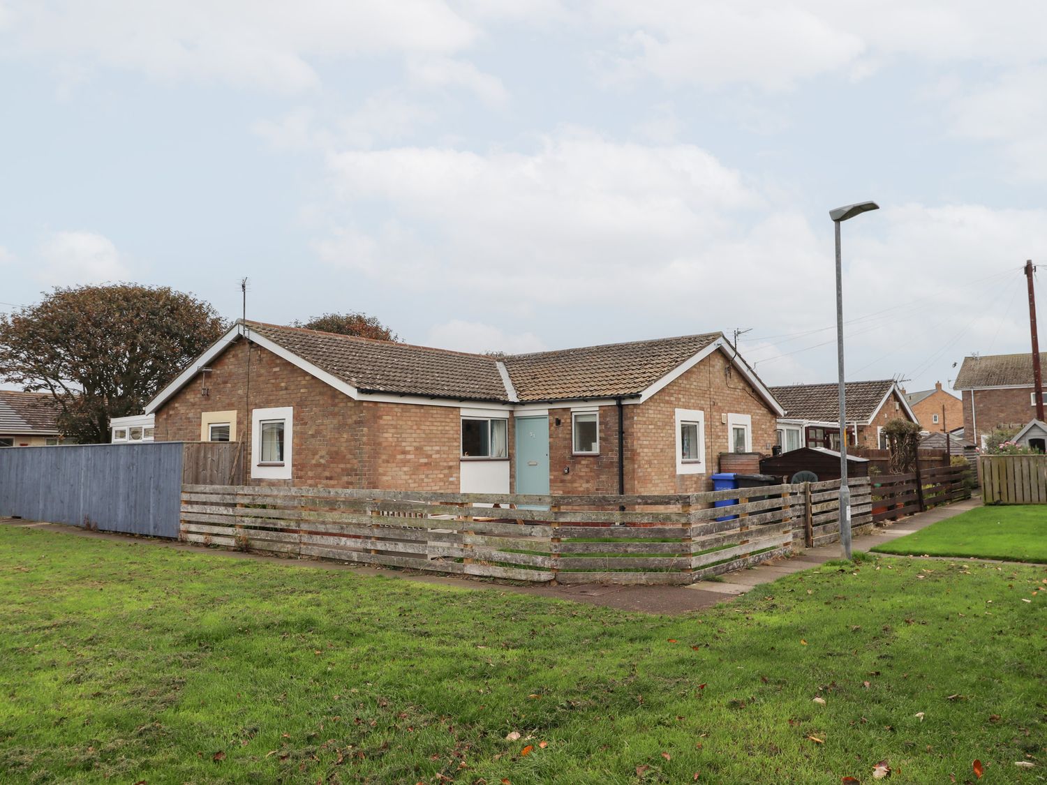 A house with a fence and grass area at 51 Longstone Park, Beadnell