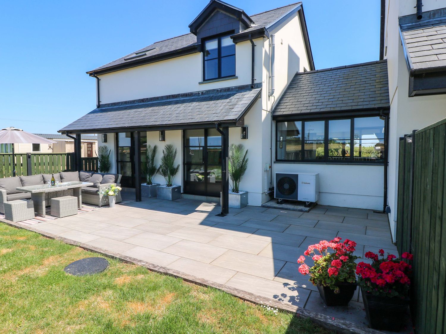 A garden with patio furniture and plants at Just A Cottage St Florence