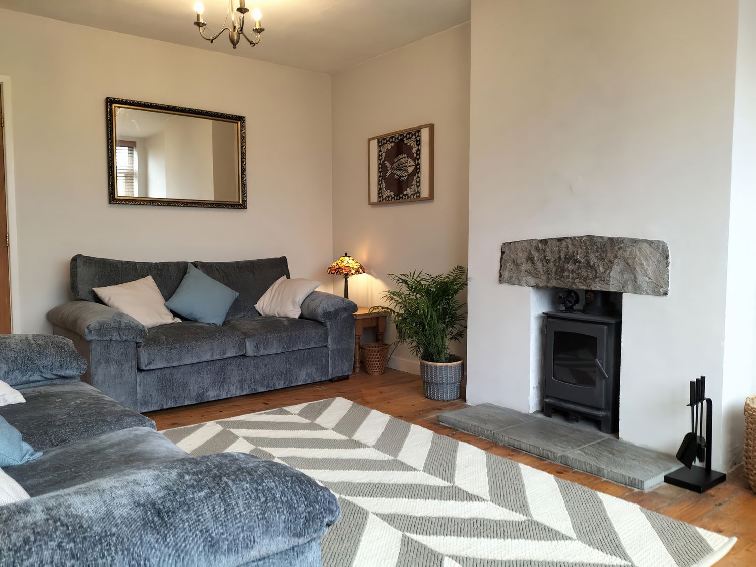 A living room with a sofa and fireplace at 1 Maes Y Ffynnon Menai Bridge