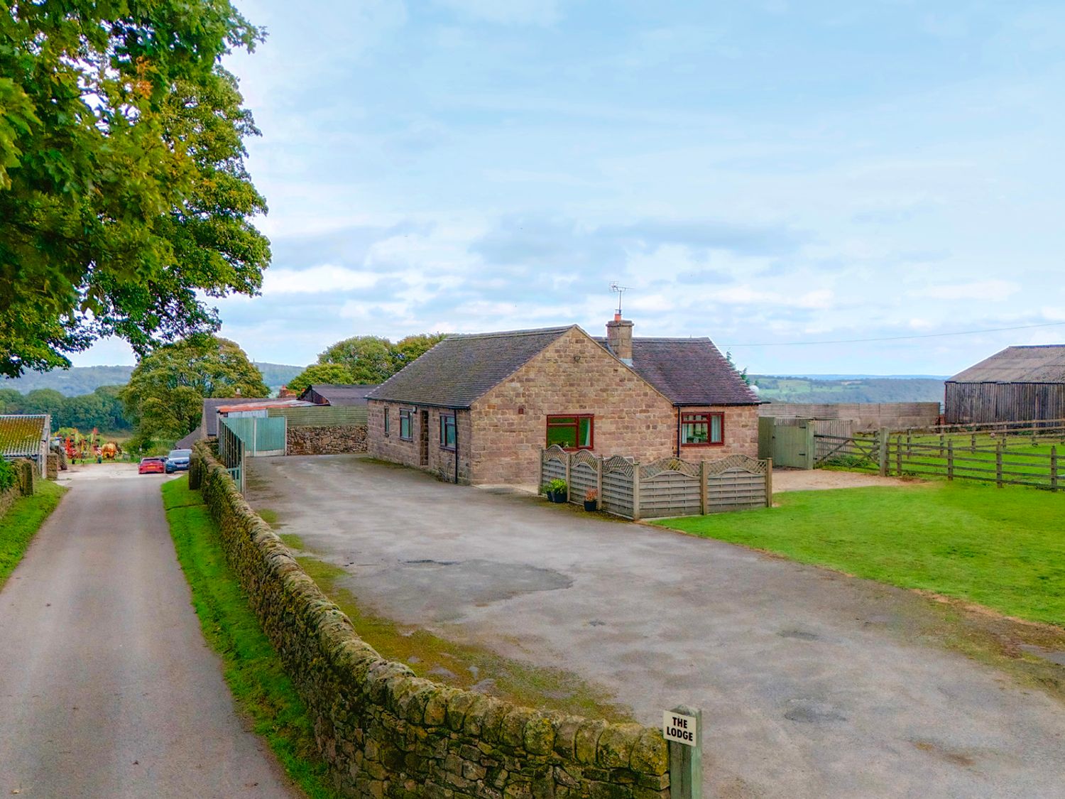 A bungalow with a driveway and barn at The Lodge in Wirksworth