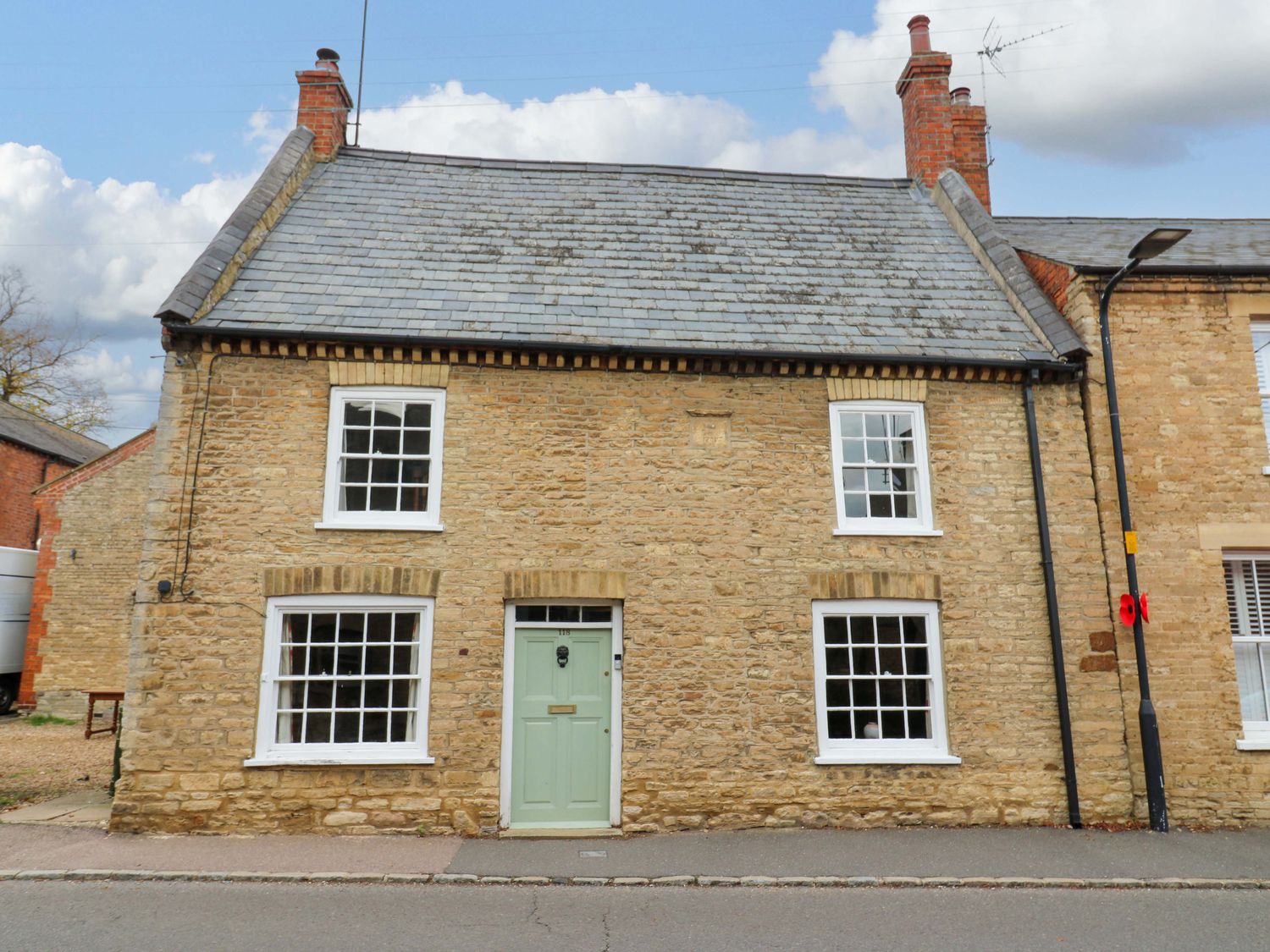A house with a green door and multiple windows at 118 High Street Bedford
