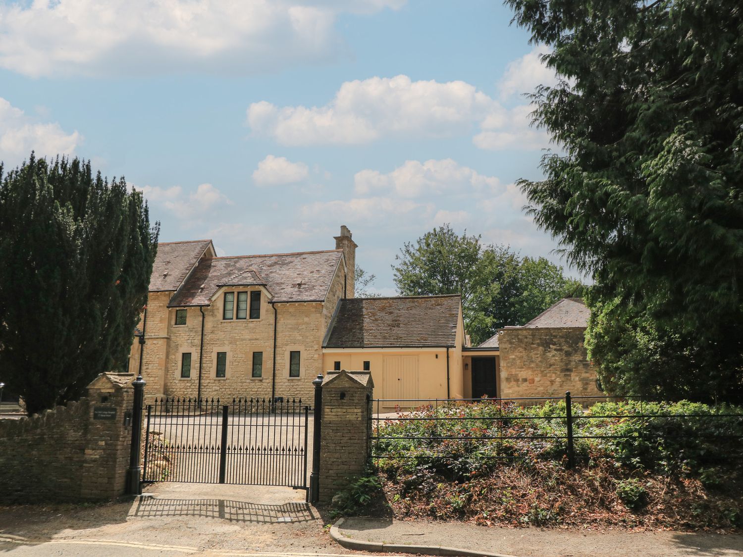 A building with a gate and trees at the Old Cottage Hospital Annexe Burford